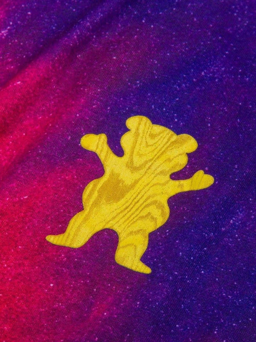  壁紙 — 一個帶有木紋紋理的黃色熊剪影漂浮在充滿星星的紫色和粉紅色鮮豔宇宙漸變背景上。