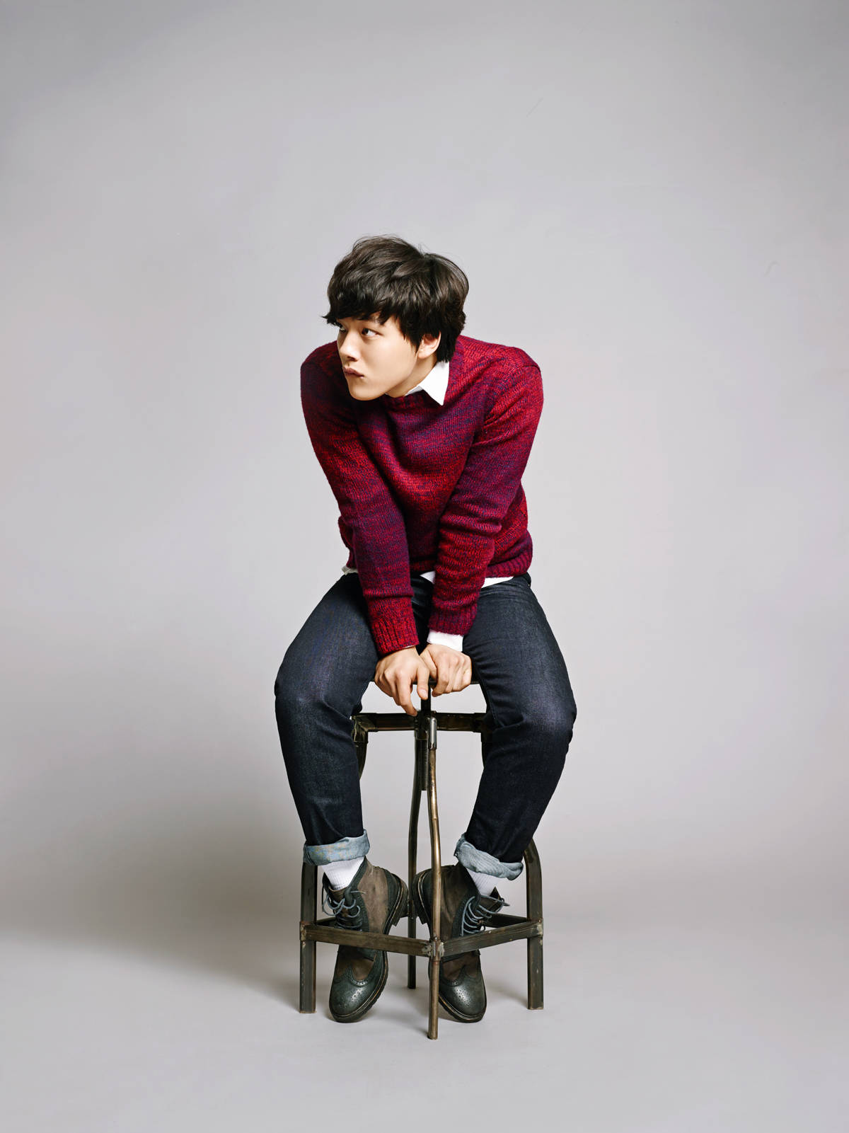 Yeo Jin Goo 穿紅色服裝展現魅力 壁紙 — 一位穿著紅色毛衣的年輕男子坐在金屬凳子上，背景是純灰色攝影棚。