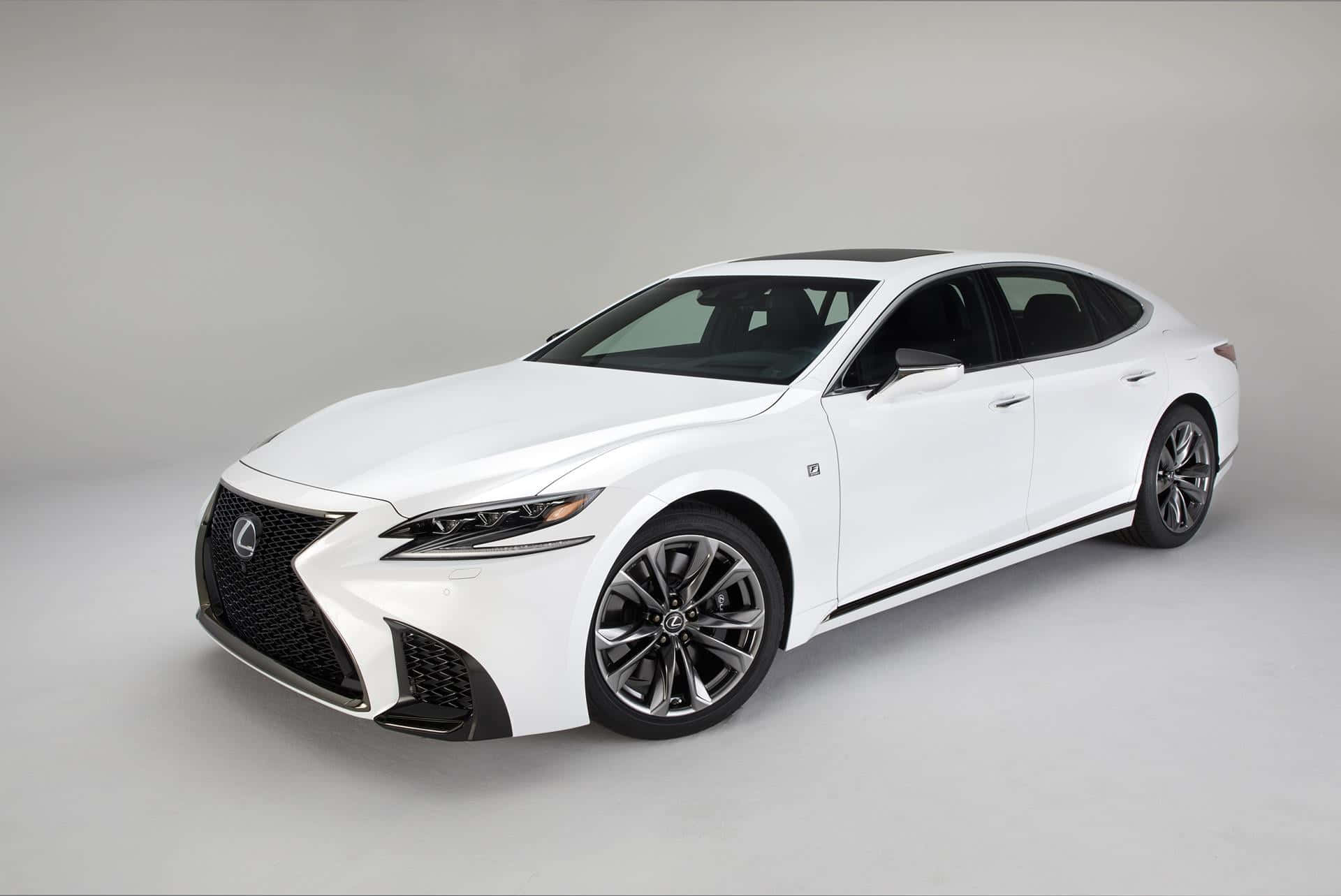 Lexus Ls 500 桌布 壁紙 — 一部純白色Lexus房車，線條流暢，帶黑色飾邊，在簡約的攝影棚環境中展示。