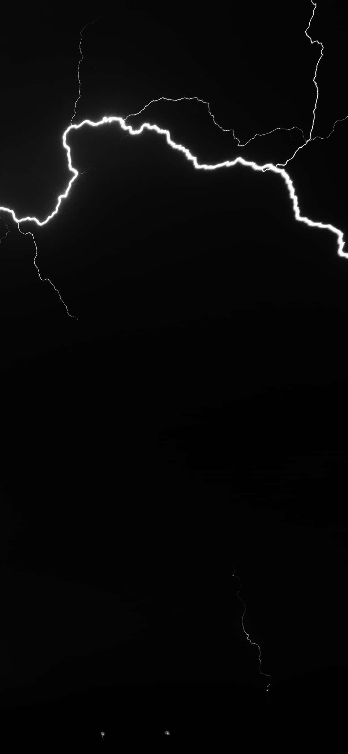 Lightning iPhone 桌布 壁紙 — 一道鋸齒狀的閃電在漆黑天空中分叉，呈現高對比度的黑白畫面。