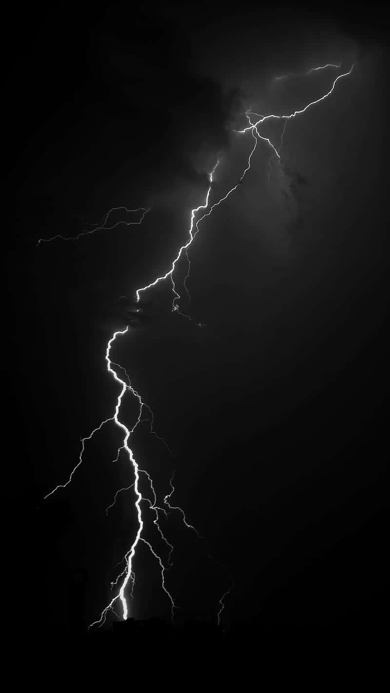 Lightning iPhone 桌布 壁紙 — 一道巨大的閃電在漆黑的天空中戲劇性地垂直劈開，分叉成多條。