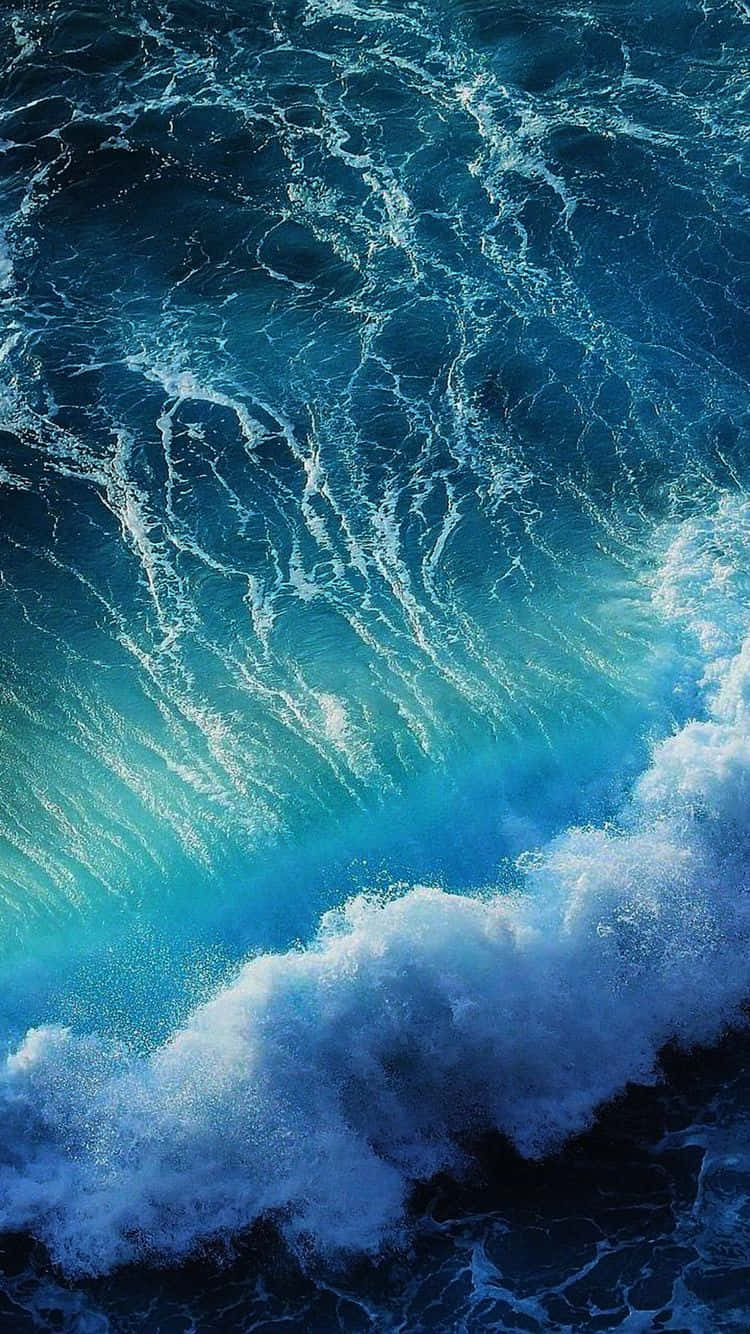 waves 桌布 壁紙 — 一道強勁的海浪捲起並破碎，呈現出藍綠色和深藍色的色調，營造出動感且富有紋理的海景。