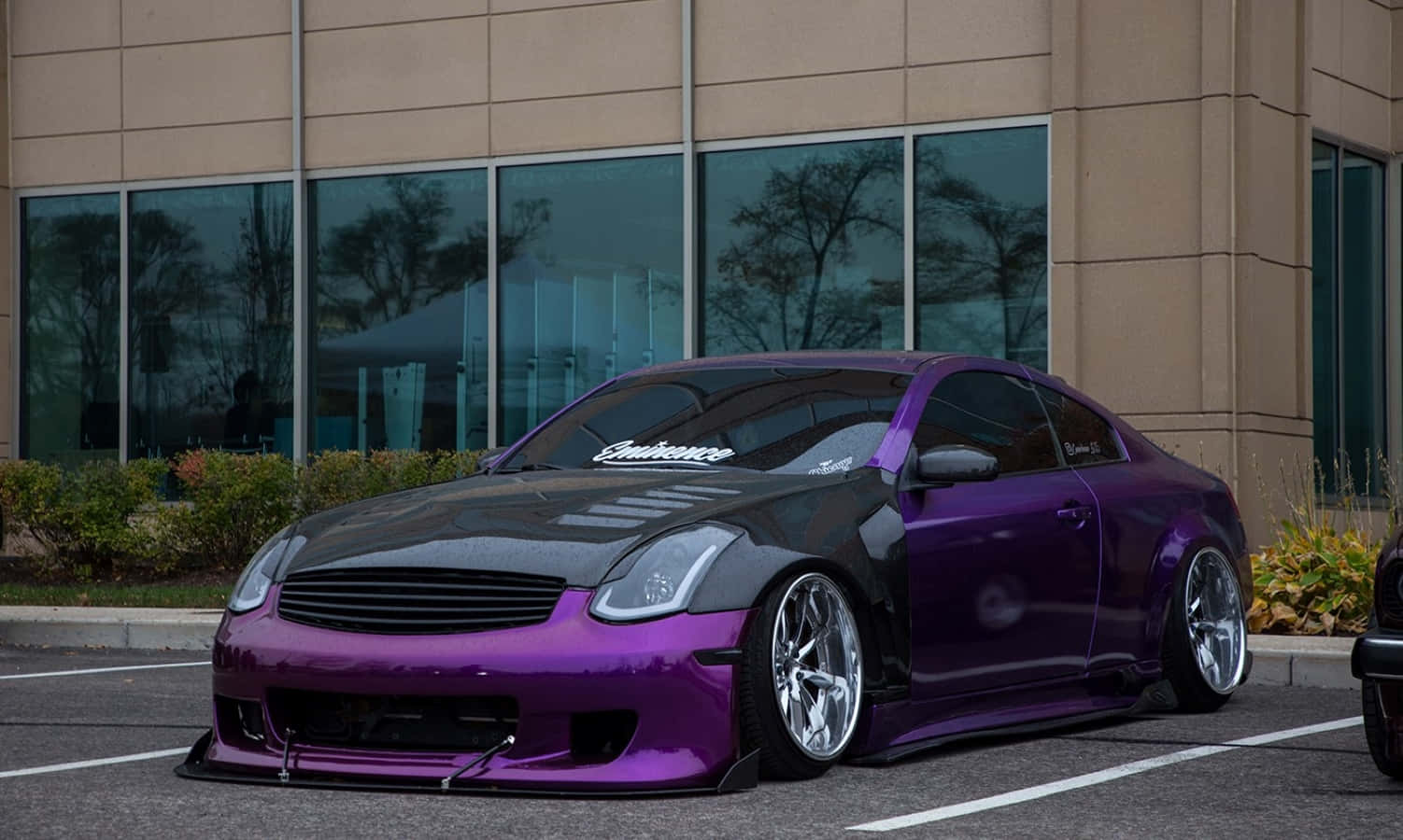Infiniti G35 桌布 壁紙 — 一架低矮的紫色和黑色訂製跑車停泊在現代玻璃建築前。