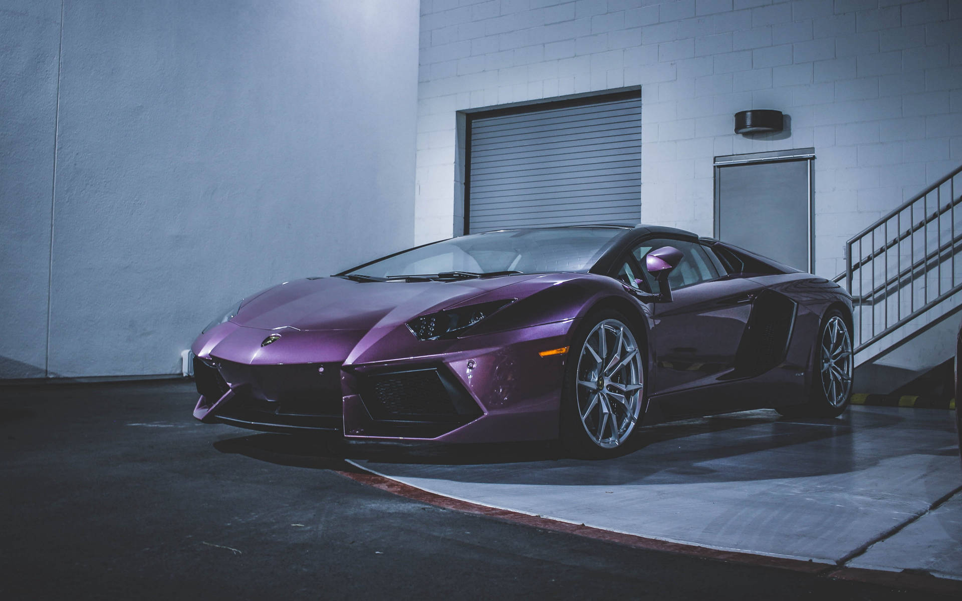 紫色林寶堅尼Aventador停泊在混凝土車庫，內有金屬樓梯。