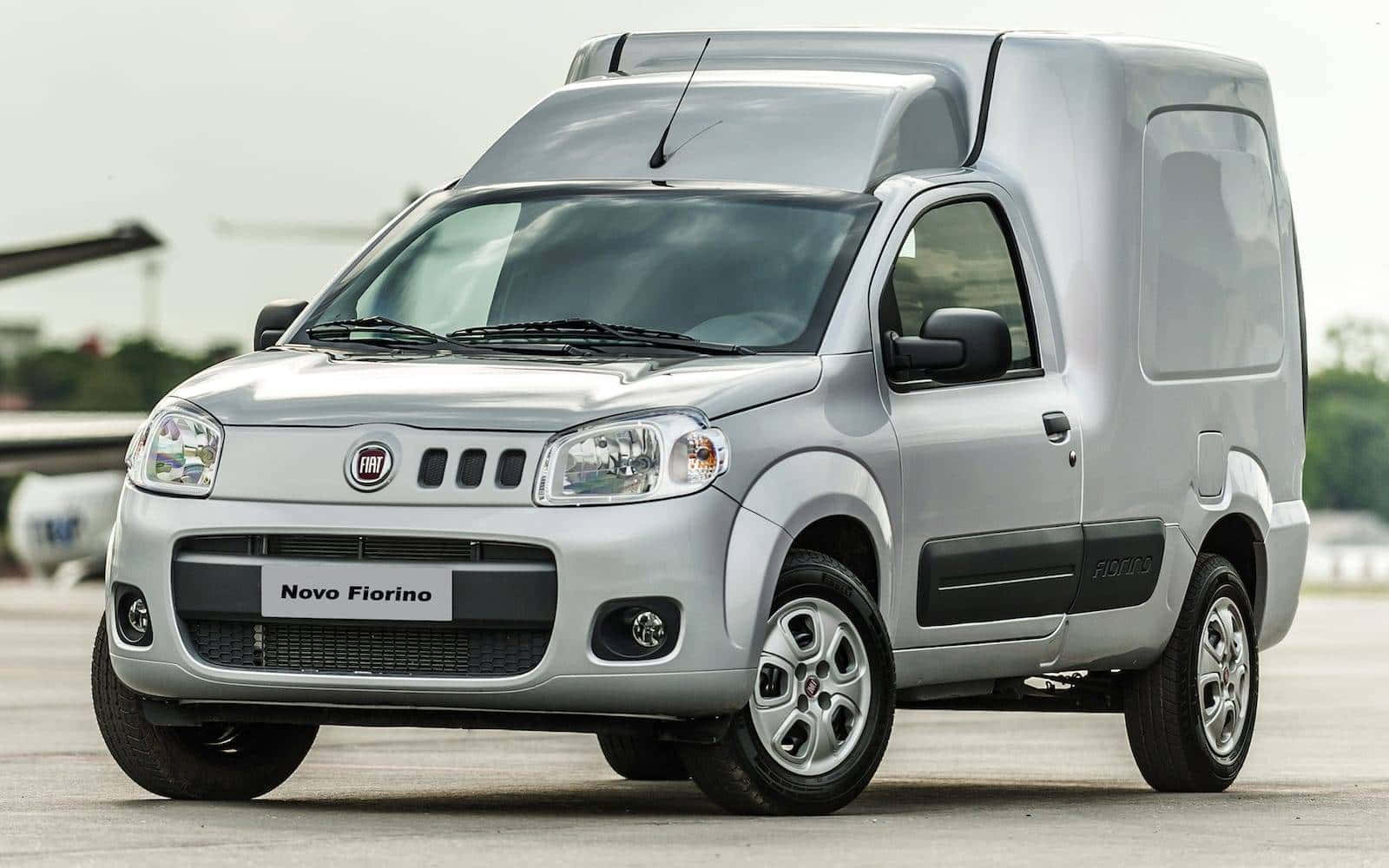 Fiat Fiorino 桌布 壁紙 — 一架時尚的銀色 Fiat Novo Fiorino 客貨車停泊在露天鋪砌場地上，天空多雲。