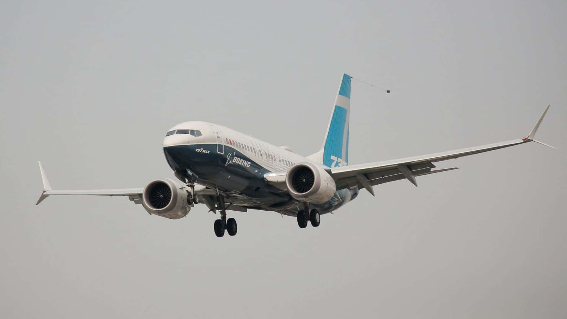  壁紙 — 一架波音737 MAX飛機放下起落架，在灰濛濛的天空中下降。
