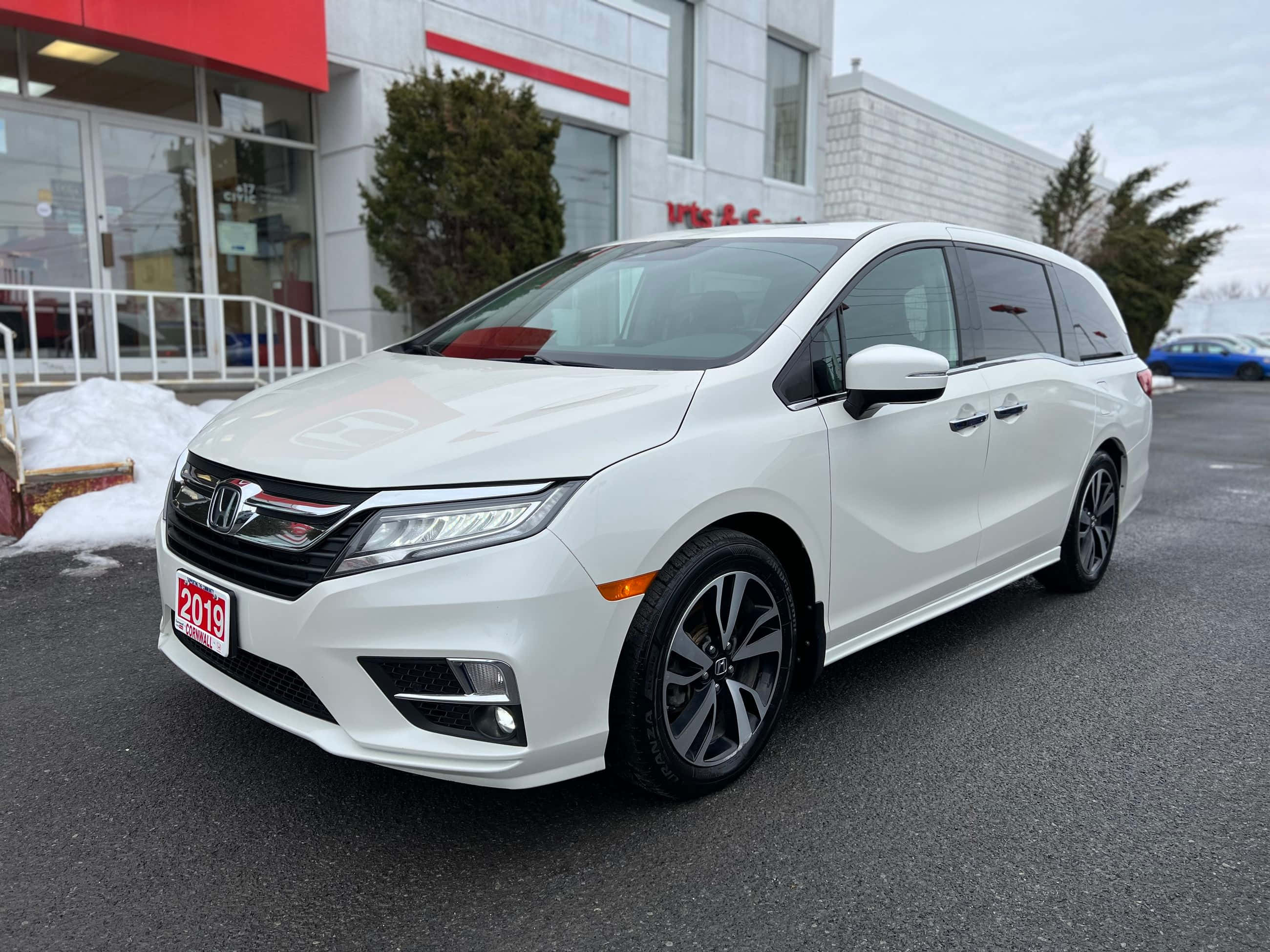 Honda Odyssey 桌布 壁紙 — 一架純白色的2019年本田Odyssey小型貨車停泊在經銷商外，附近有雪堆。