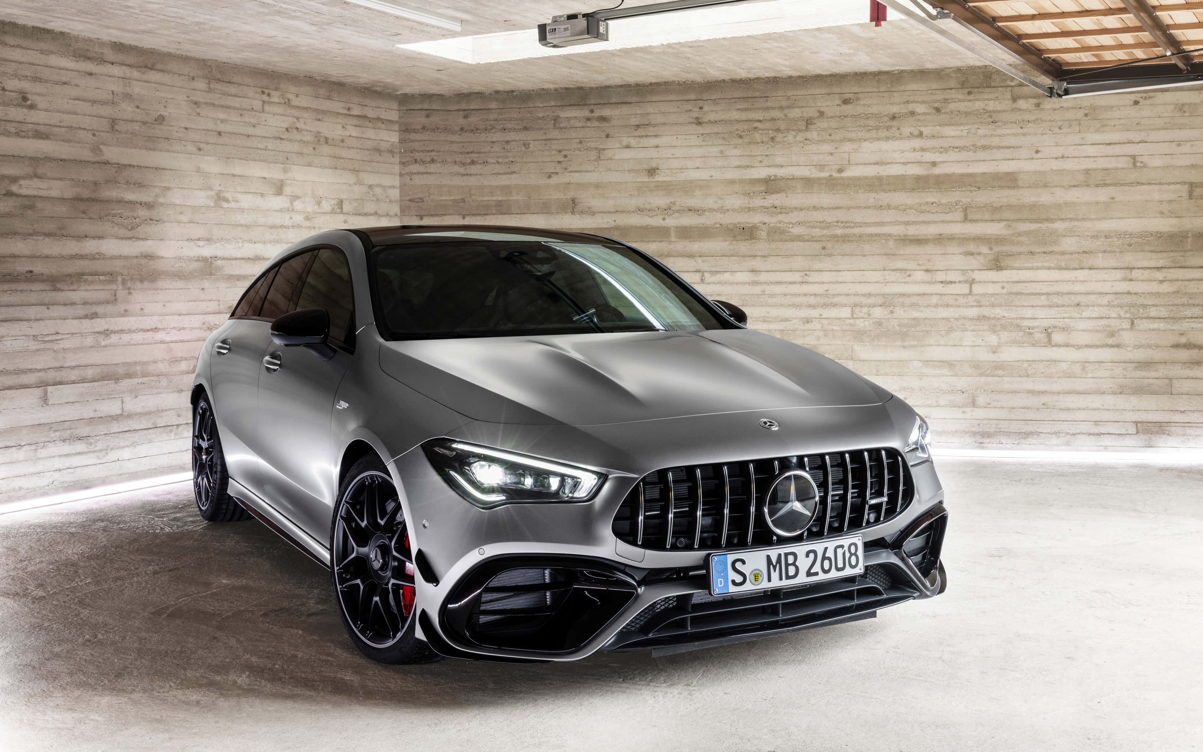 Mercedes Benz Cla-class 桌布 壁紙 — 一架時尚的啞光灰色 Mercedes-AMG CLA 45 S 停泊在一個簡約的混凝土車庫中，帶有裸露的木樑。