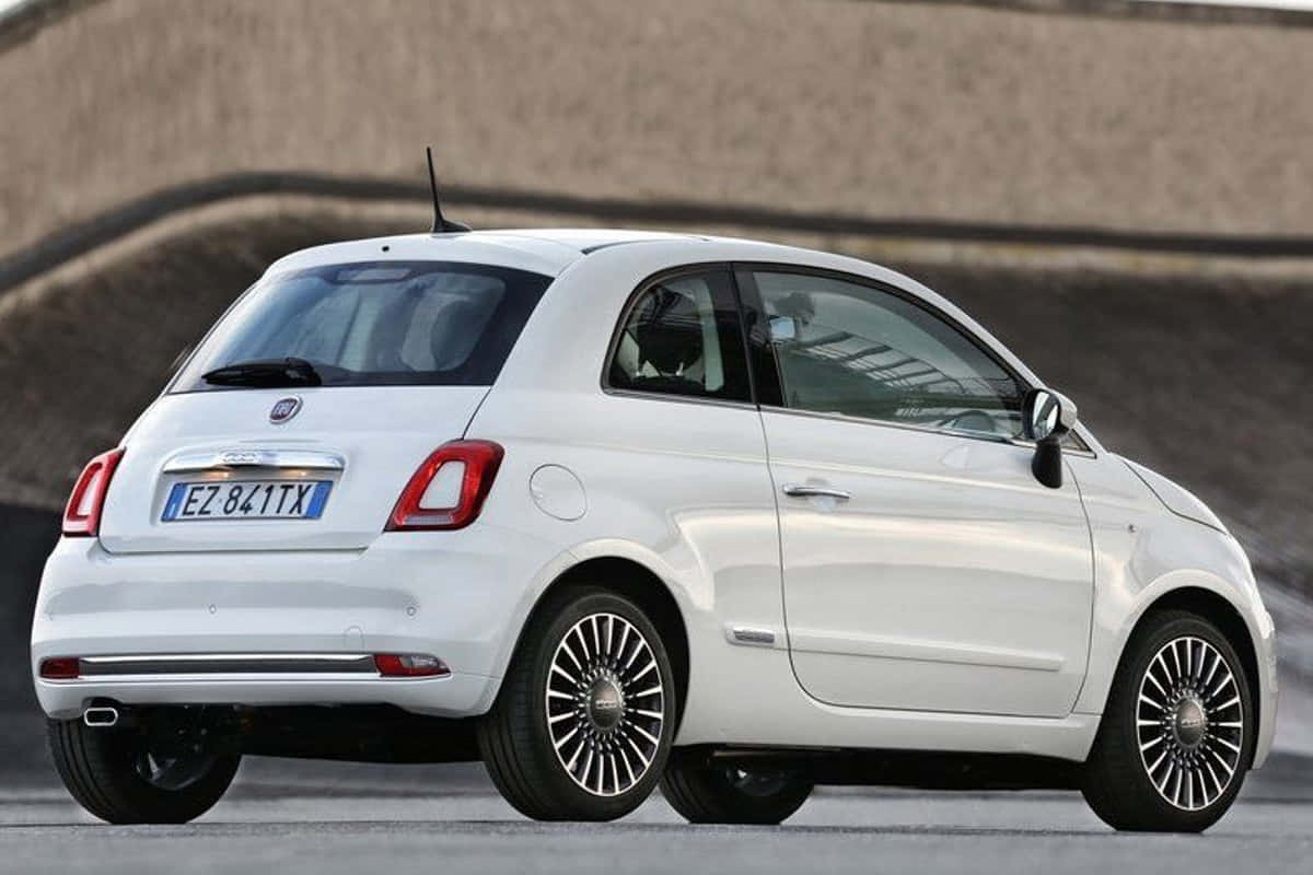 Fiat 500 桌布 壁紙 — 一架時尚的白色Fiat 500停泊在瀝青路上，背景是混凝土牆。