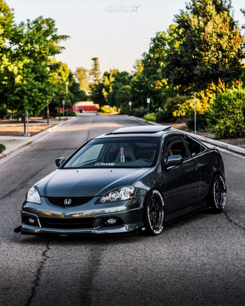 Acura Rsx 桌布 壁紙 — 一架時尚的深灰色改裝本田轎跑車停泊在樹蔭街道上，沐浴在金色的夕陽光芒中。