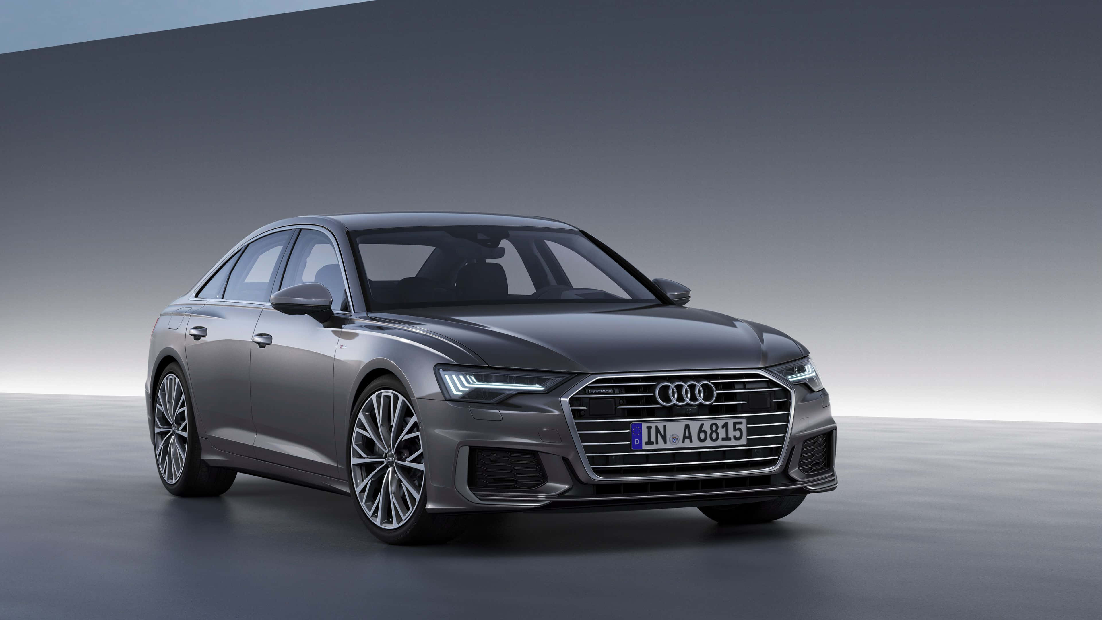 Audi A6 桌布 壁紙 — 一架時尚的灰色奧迪A6房車在簡約風格的攝影棚中展示，配有柔和燈光和漸變灰色背景。
