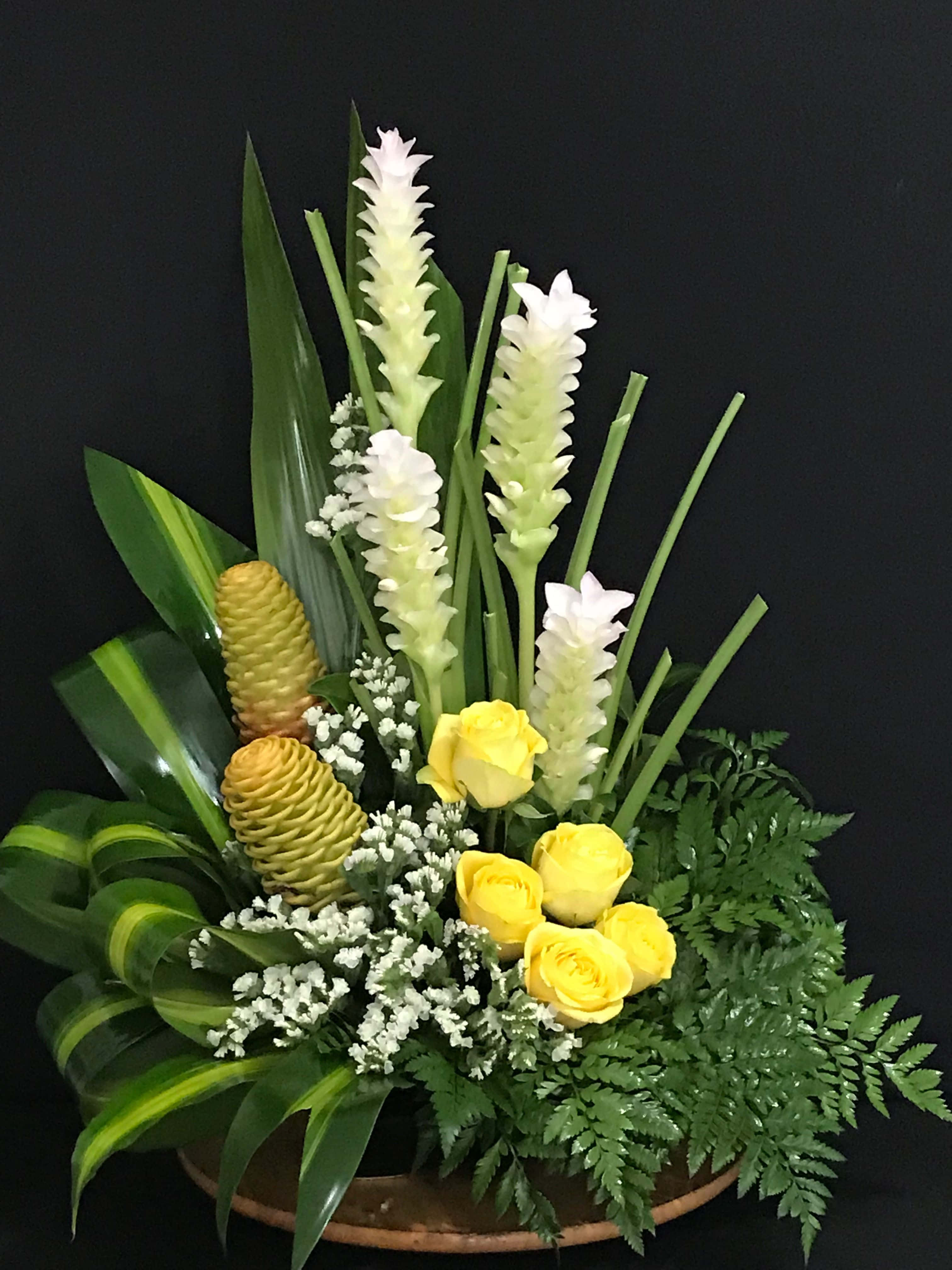 Flower Arrangement 桌布 壁紙 — 一個充滿活力的花卉佈置，包含黃玫瑰、白蘭花和綠色葉子，以黑色背景襯托。