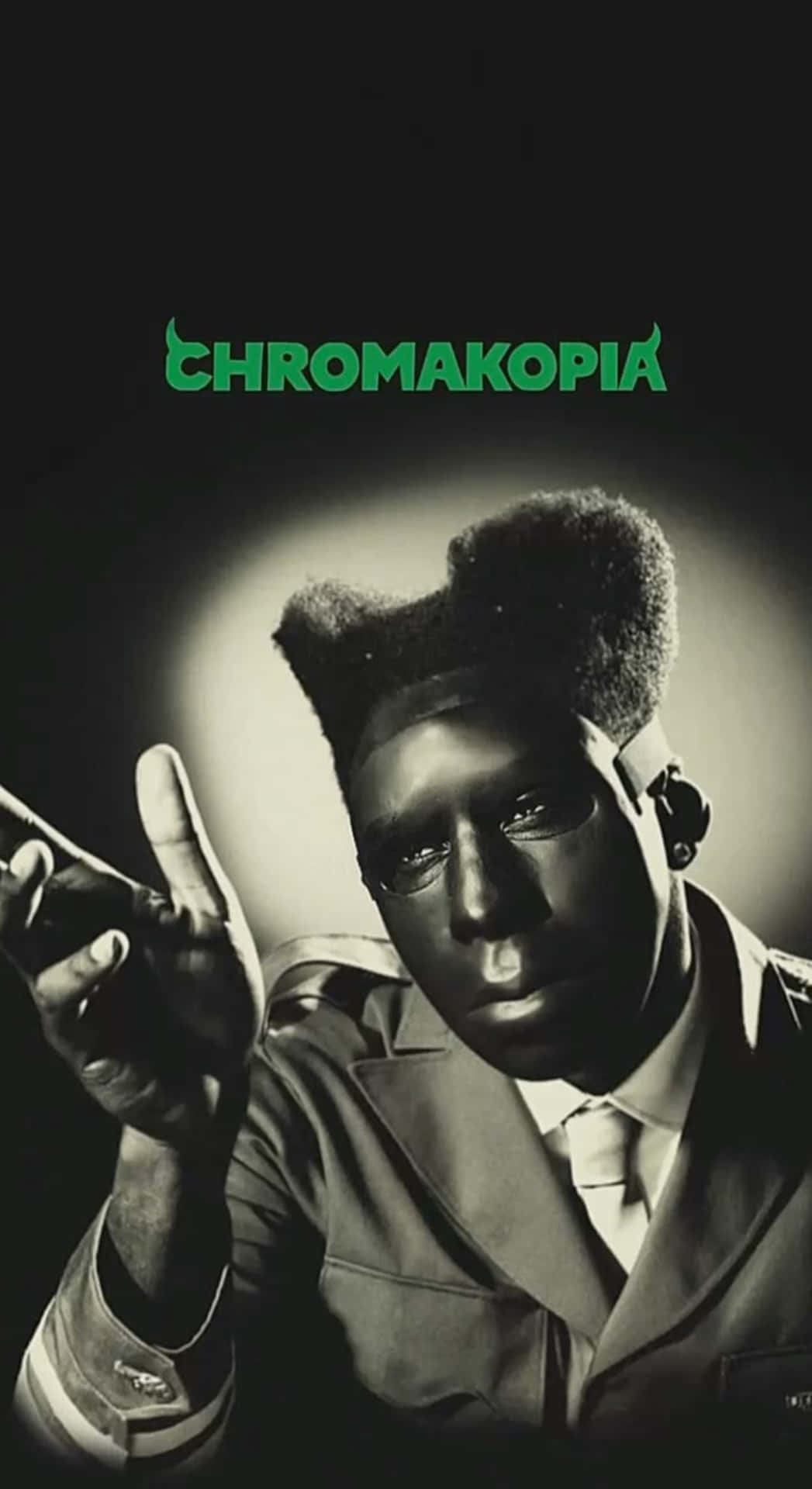  壁紙 — 一個穿著西裝的男人的黑白肖像，上方有一個綠色的「CHROMAKOPIA」標誌。