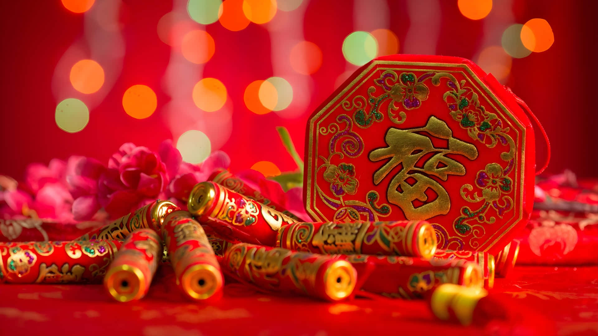  壁紙 — 一個帶有金色漢字和煙花的節日紅色八角形裝飾品放在紅色表面上，背景為散景。