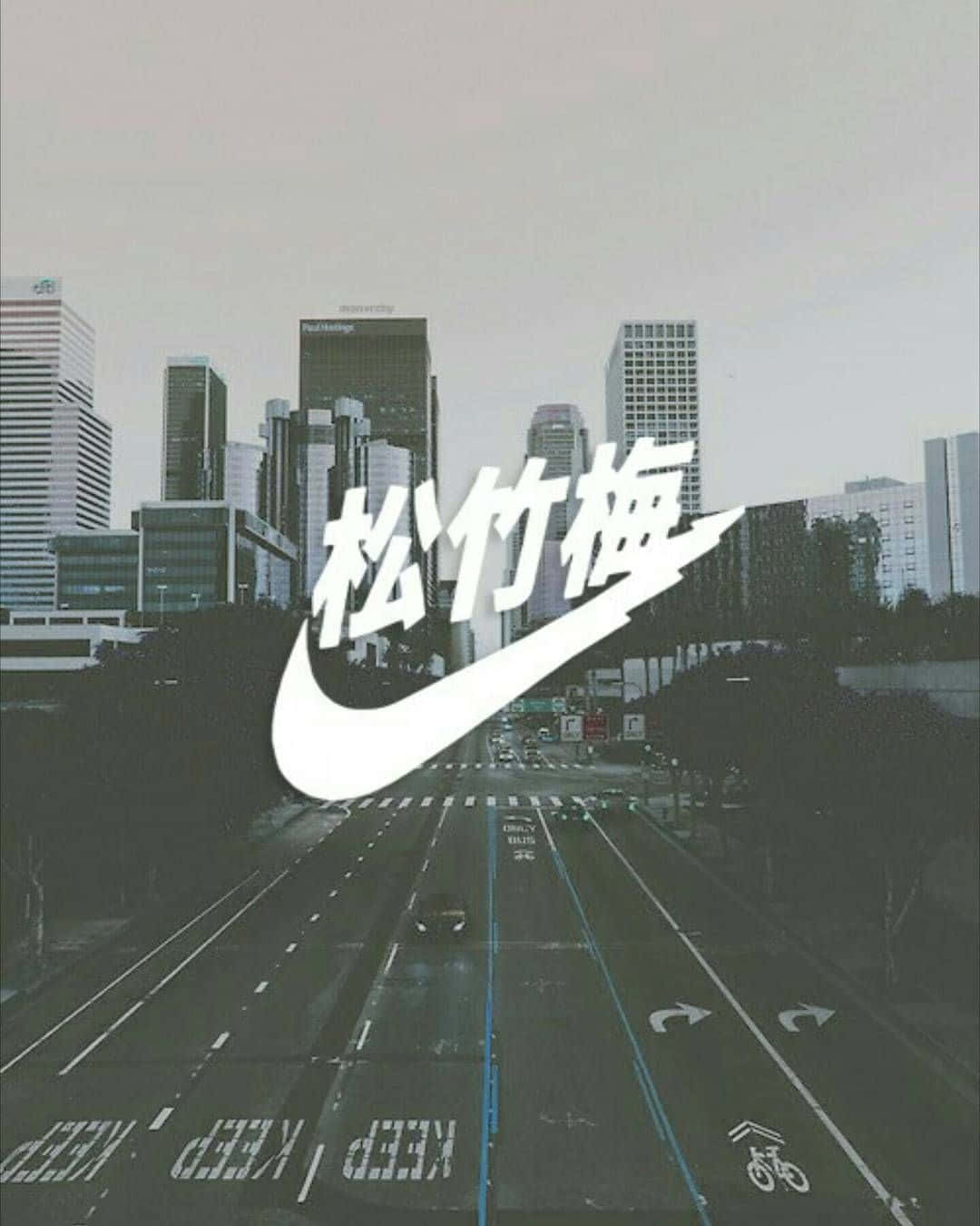  壁紙 — 一個風格化的Nike剔號疊加在一條單色城市街道上，街道上有高樓大廈和道路標記，天空多雲。