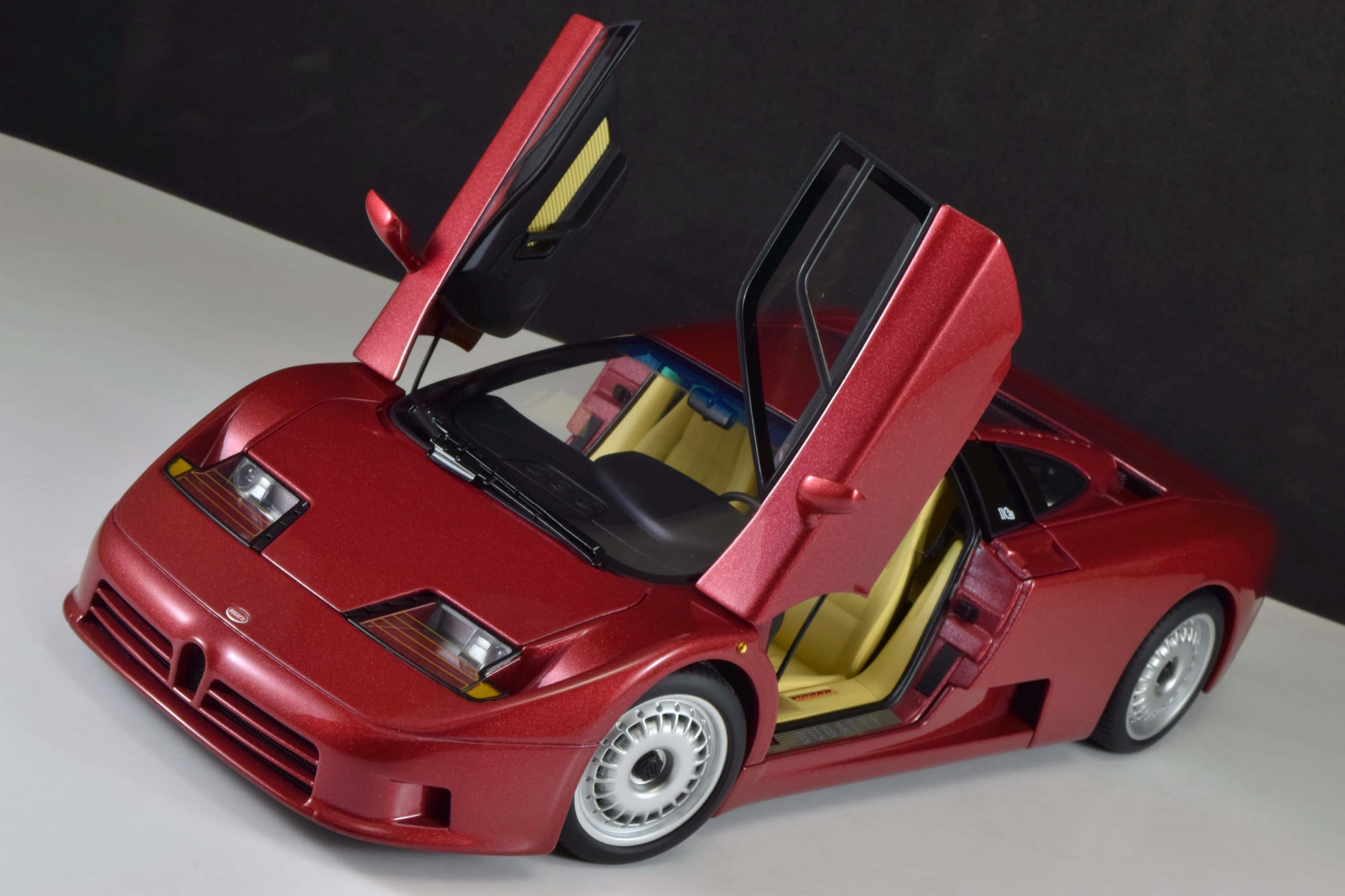 Bugatti Eb110 桌布 壁紙 — 一個光澤的紅色林寶堅尼Diablo模型，剪刀門打開，露出黃色內飾，放在白色表面上。