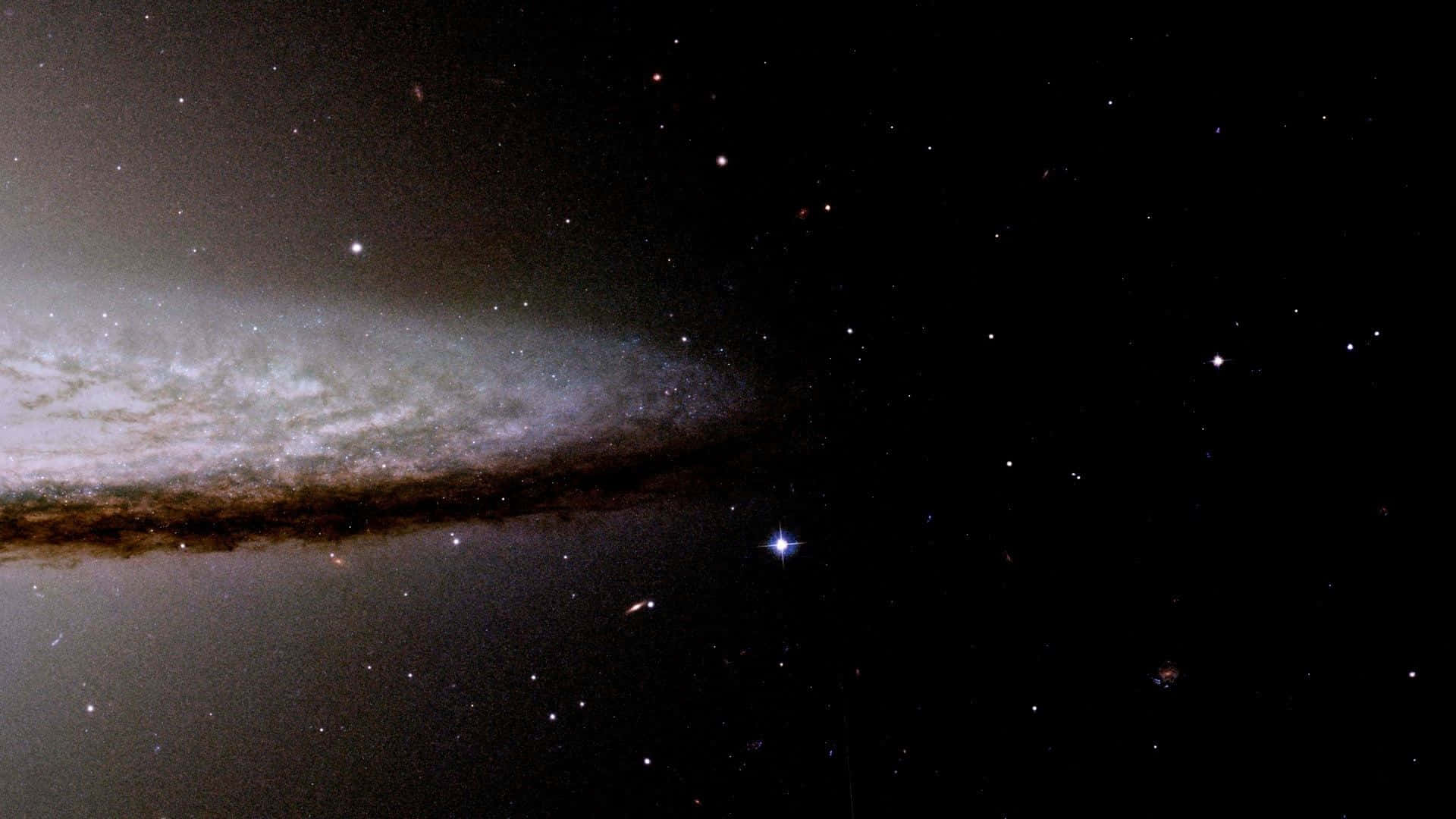  壁紙 — 一個宏偉的螺旋星系在佈滿恆星的宇宙虛空中旋轉，伴隨著發光的星雲和遙遠的明亮恆星。