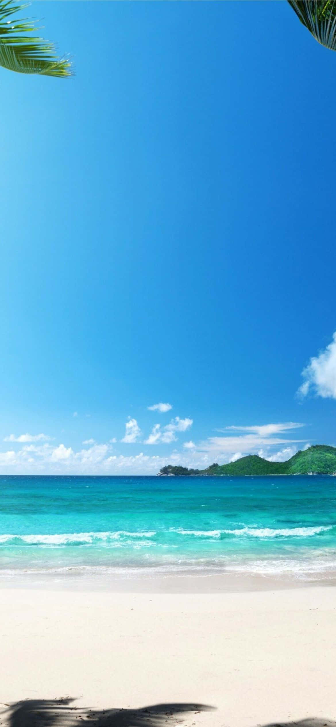 熱帶海灘，有碧綠的海水、白色的沙灘和綠色的山丘，在晴朗的藍天下。