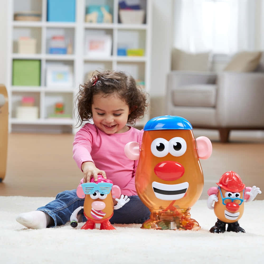 小女孩在白色地毯上玩 Mr Potato Head 玩具時微笑。