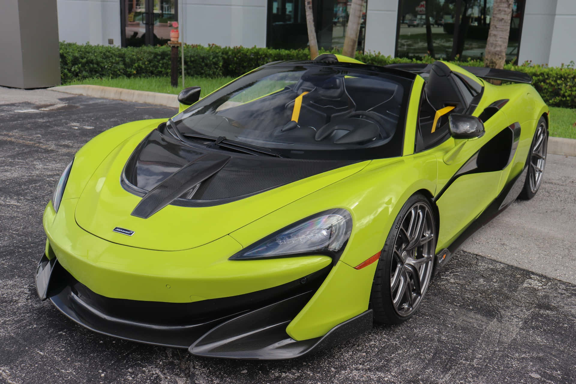 Mclaren 600lt Spider 桌布 壁紙 — 一輛充滿活力的檸檬綠McLaren 650S Spider開篷跑車停在瀝青路上，帶有黑色飾邊和流線型空氣動力學設計。