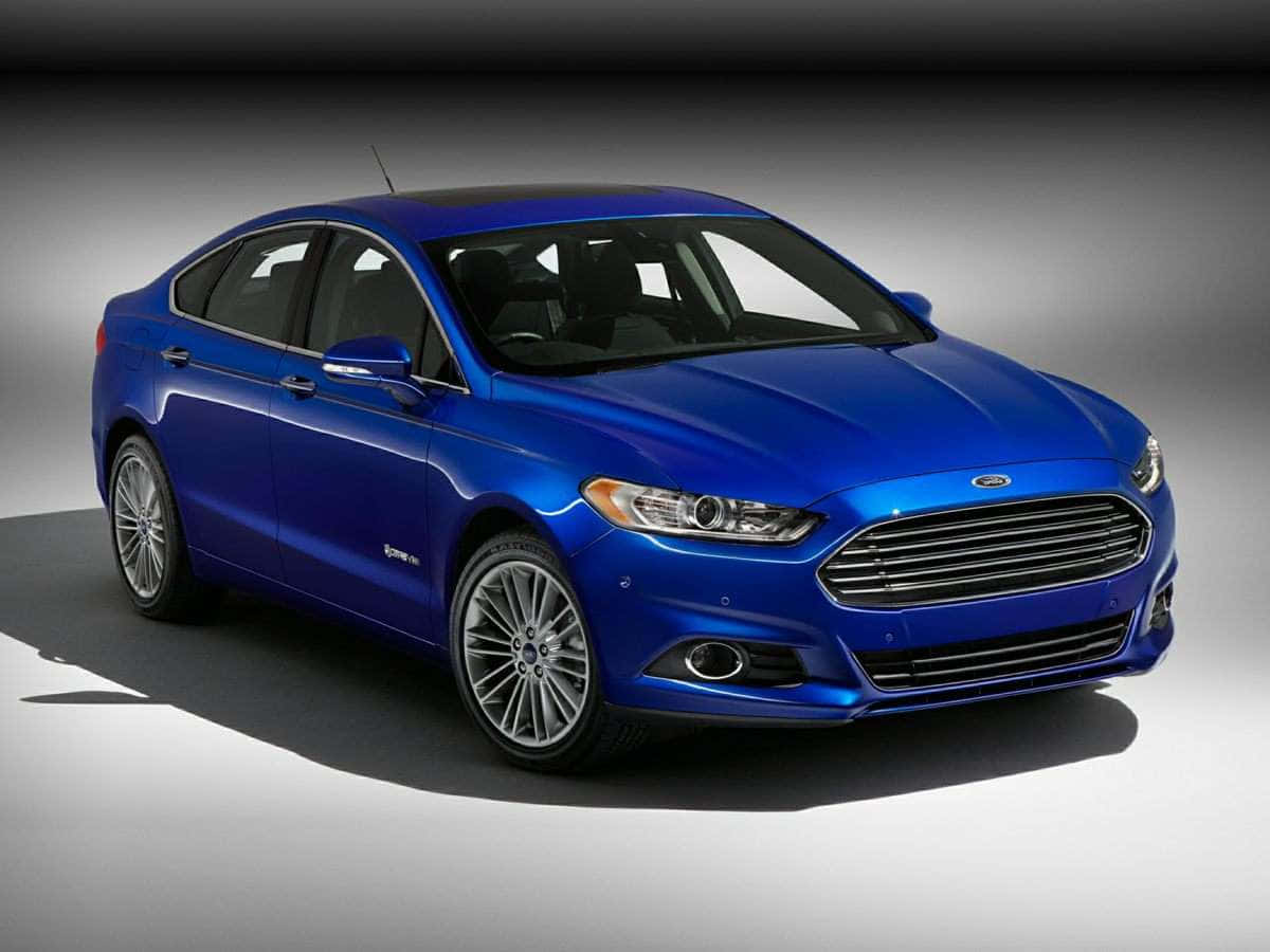 Ford Fusion 桌布 壁紙 — 一輛光澤的藍色福特Fusion房車在攝影棚內以戲劇性燈光和漸變灰色背景展示。