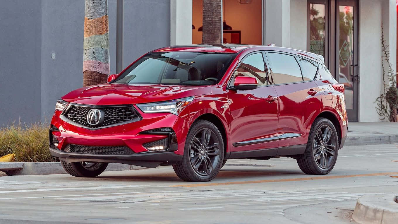 Acura Rdx 桌布 壁紙 — 一輛亮紅色的Acura SUV停泊在城市的街道上，背景有現代建築和棕櫚樹。
