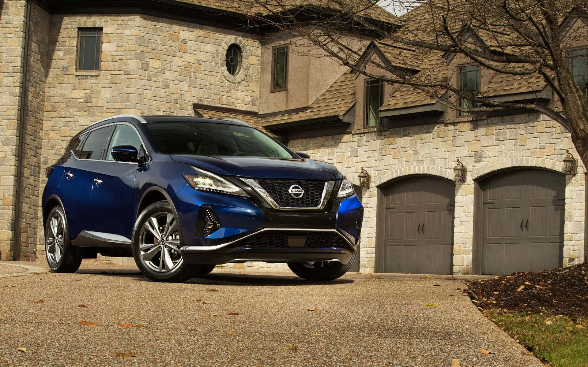 Nissan Murano 桌布 壁紙 — 一輛亮藍色的日產Rogue SUV停在一間石屋前，車道散落著秋葉。