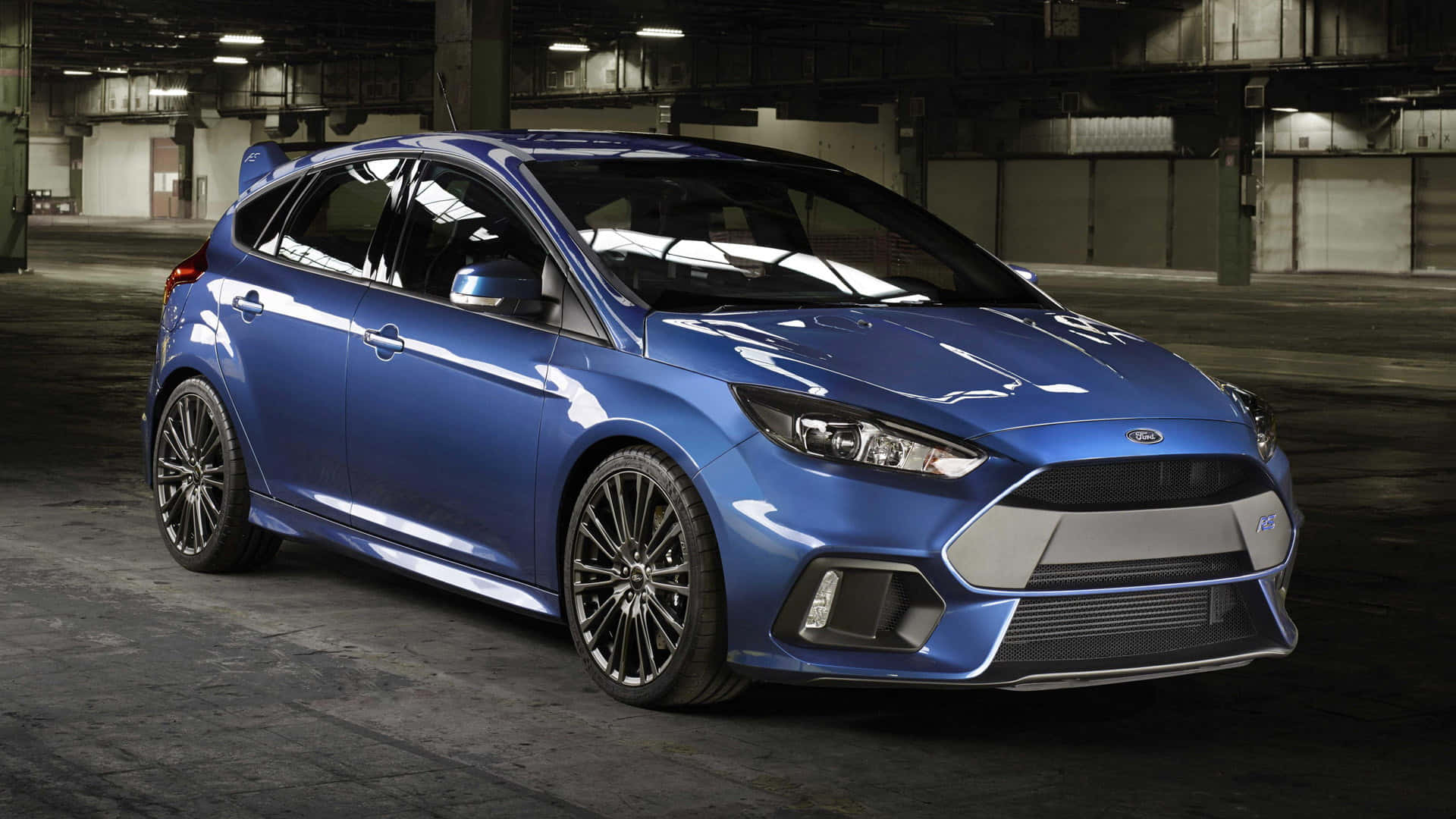 Ford Focus 桌布 壁紙 — 一輛閃亮的藍色福特福克斯RS跑車在寬敞的混凝土倉庫中，在工業照明下閃閃發光。