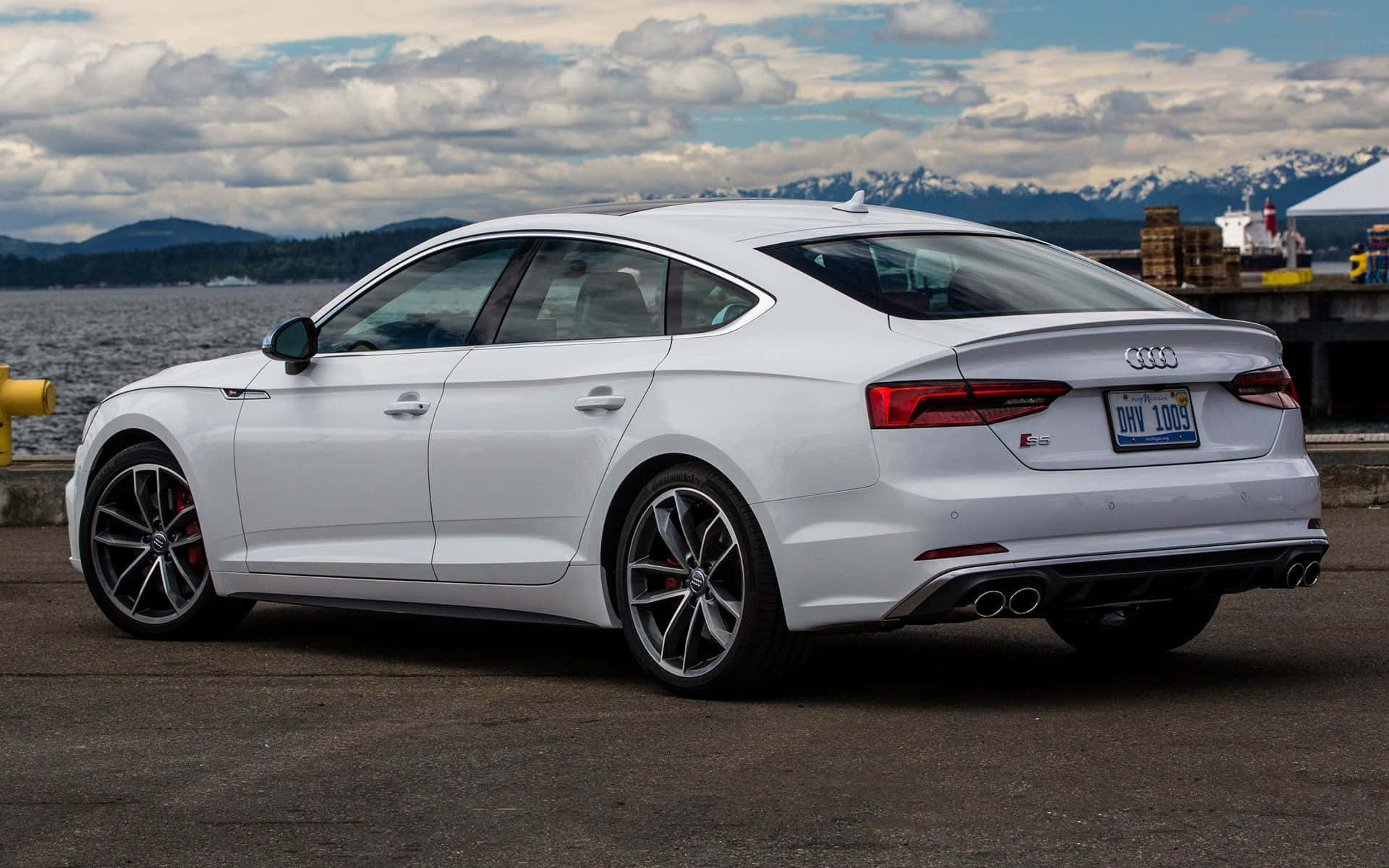 Audi S5 桌布 壁紙 — 一輛時尚的白色奧迪S5轎車停在海濱，背景是白雪覆蓋的山脈和陰天。