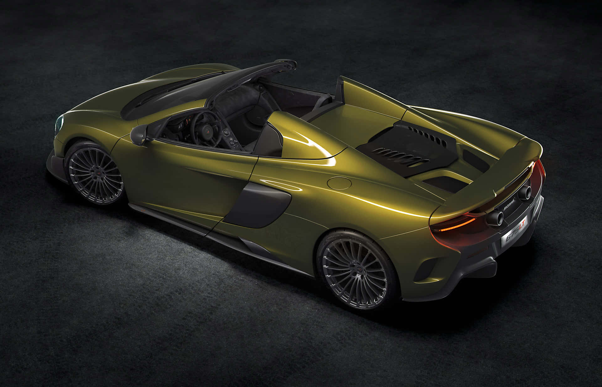 Mclaren 675lt Spider 桌布 壁紙 — 一輛時尚的橄欖綠色McLaren跑車配備黑色軟頂，在昏暗的工作室中以戲劇性燈光展示。