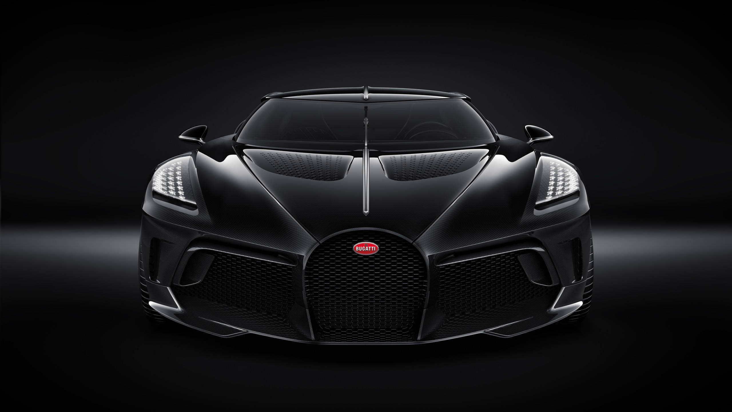 黑色Bugatti Chiron超級跑車在黑暗攝影棚環境中的正面視圖。