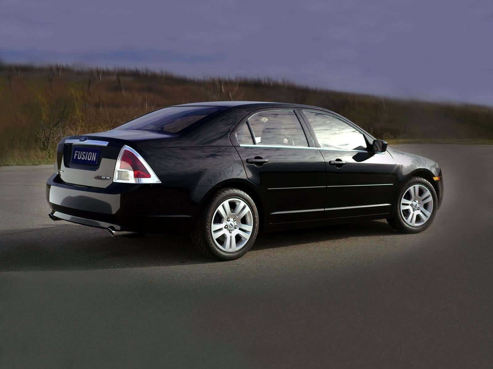Ford Fusion 桌布 壁紙 — 一輛時尚的黑色福特Fusion轎車在黃昏的天空下行駛在鋪砌的道路上，路邊的植被模糊不清。