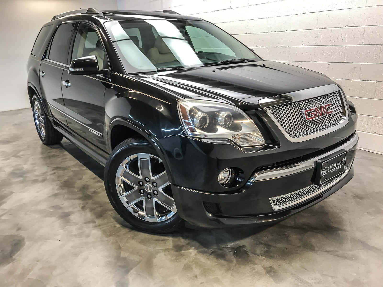 Gmc Acadia 桌布 壁紙 — 一輛時尚的黑色GMC Acadia SUV在乾淨的室內車庫中展示，車庫有拋光混凝土地板和白色磚牆。