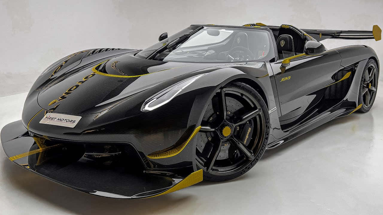  壁紙 — 一輛時尚的黑色Koenigsegg Jesko超跑，帶有醒目的黃色點綴，在純白地板上的攝影棚燈光下閃閃發光。