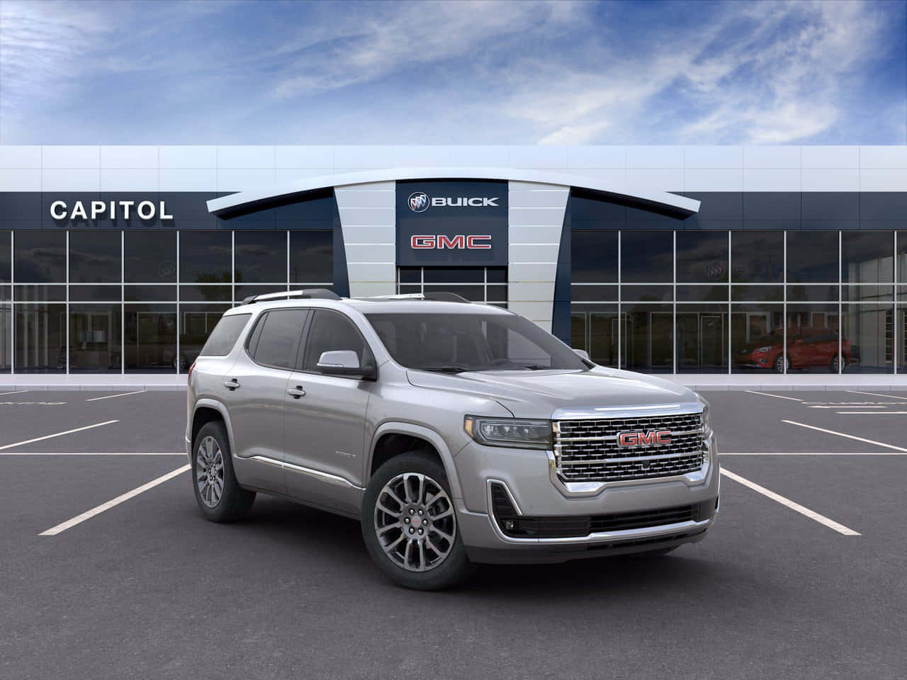 Gmc Acadia 桌布 壁紙 — 一輛時尚的銀色GMC Acadia SUV停在一間現代化的Buick GMC經銷商前，天空湛藍，雲朵稀疏。
