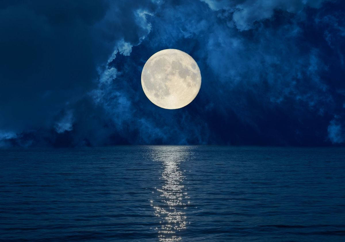 滿月映照在平靜的海洋上，夜空下烏雲密佈