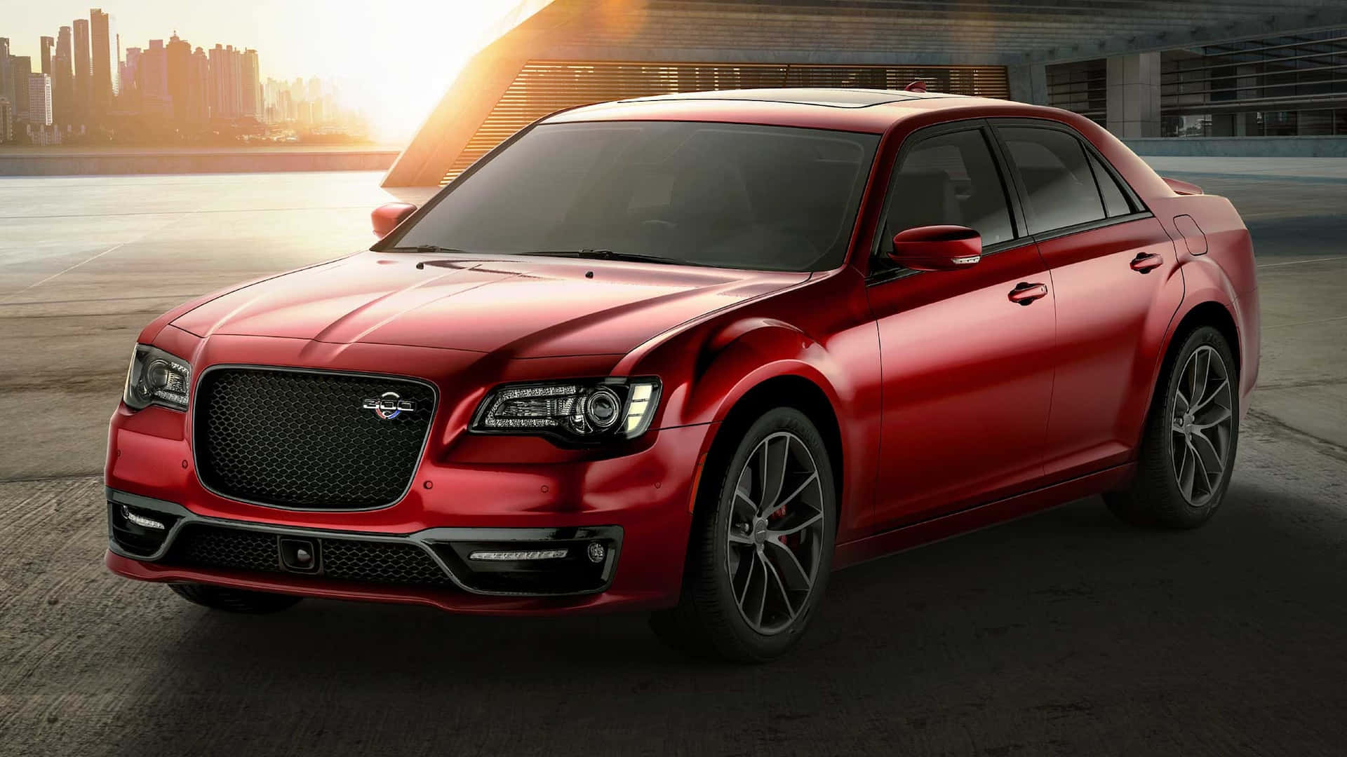 Chrysler 300 桌布 壁紙 — 一輛光亮的紅色豪華轎車在金色夕陽下閃耀，背景是現代城市天際線。
