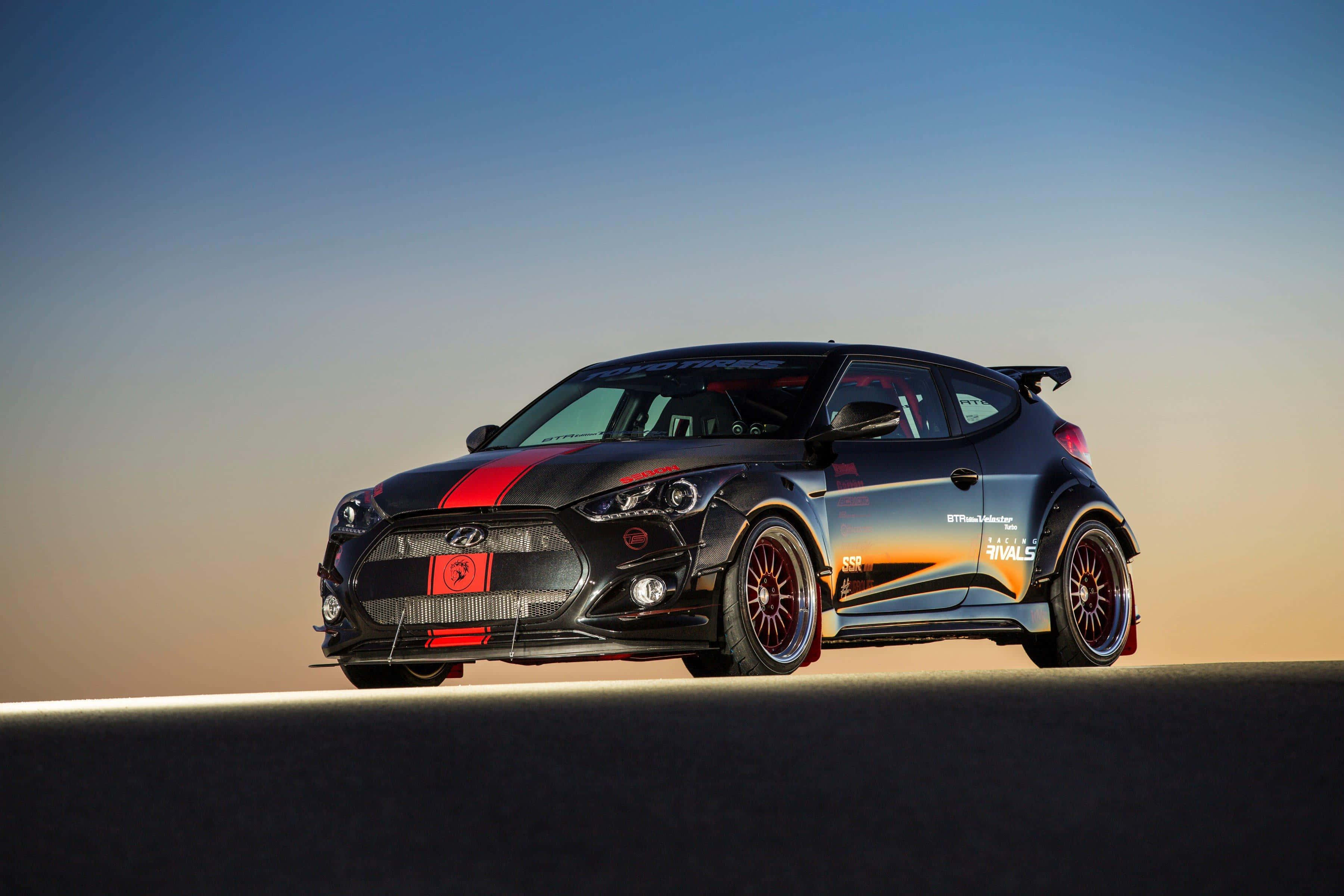 Hyundai Veloster 桌布 壁紙 — 一輛黑色現代Veloster N飄移車，帶有紅色點綴和贊助商貼紙，在日落時分停在沙漠公路上。
