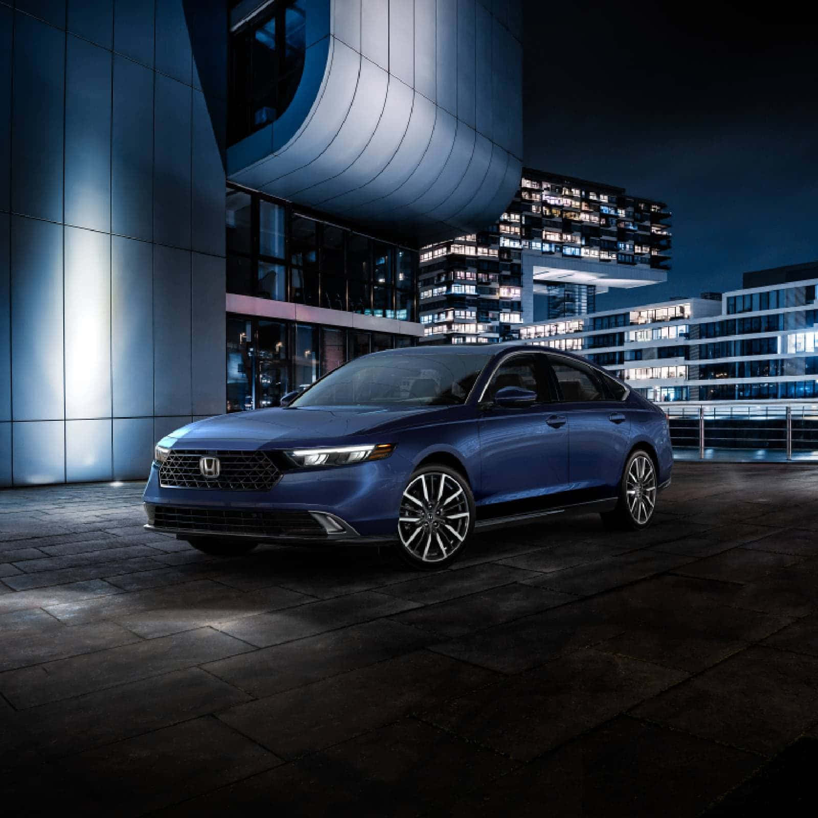 Honda Accord 桌布 壁紙 — 一輛時尚的藍色轎車在夜晚的城市燈光下閃耀，停在一棟現代建築旁。