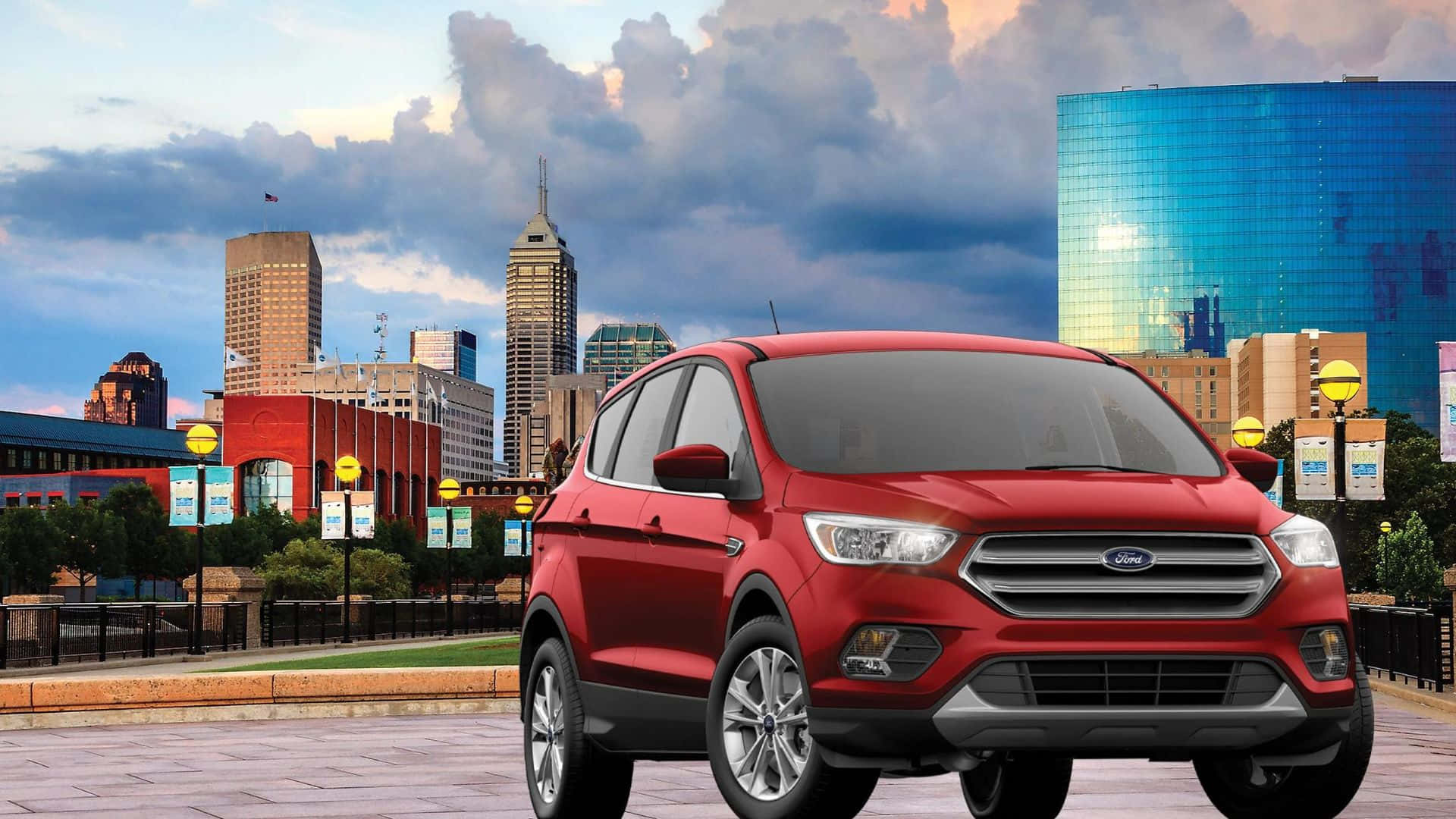 Ford Escape 桌布 壁紙 — 一輛鮮紅色的福特SUV停泊在一個城市廣場上，廣場上有現代摩天大樓和色彩繽紛的玻璃建築，背景是戲劇性的黃昏天空。