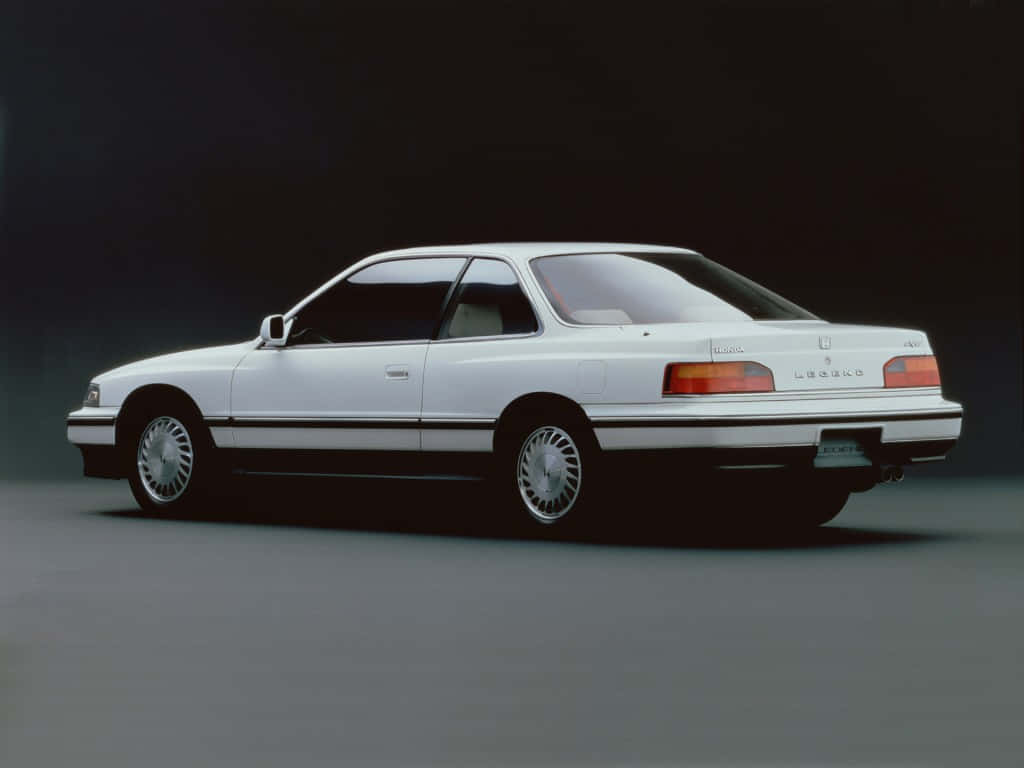 Honda Legend 桌布 壁紙 — 一輛純白色的凌志LS400轎跑車在攝影棚燈光下，於深色漸變背景前滑行。