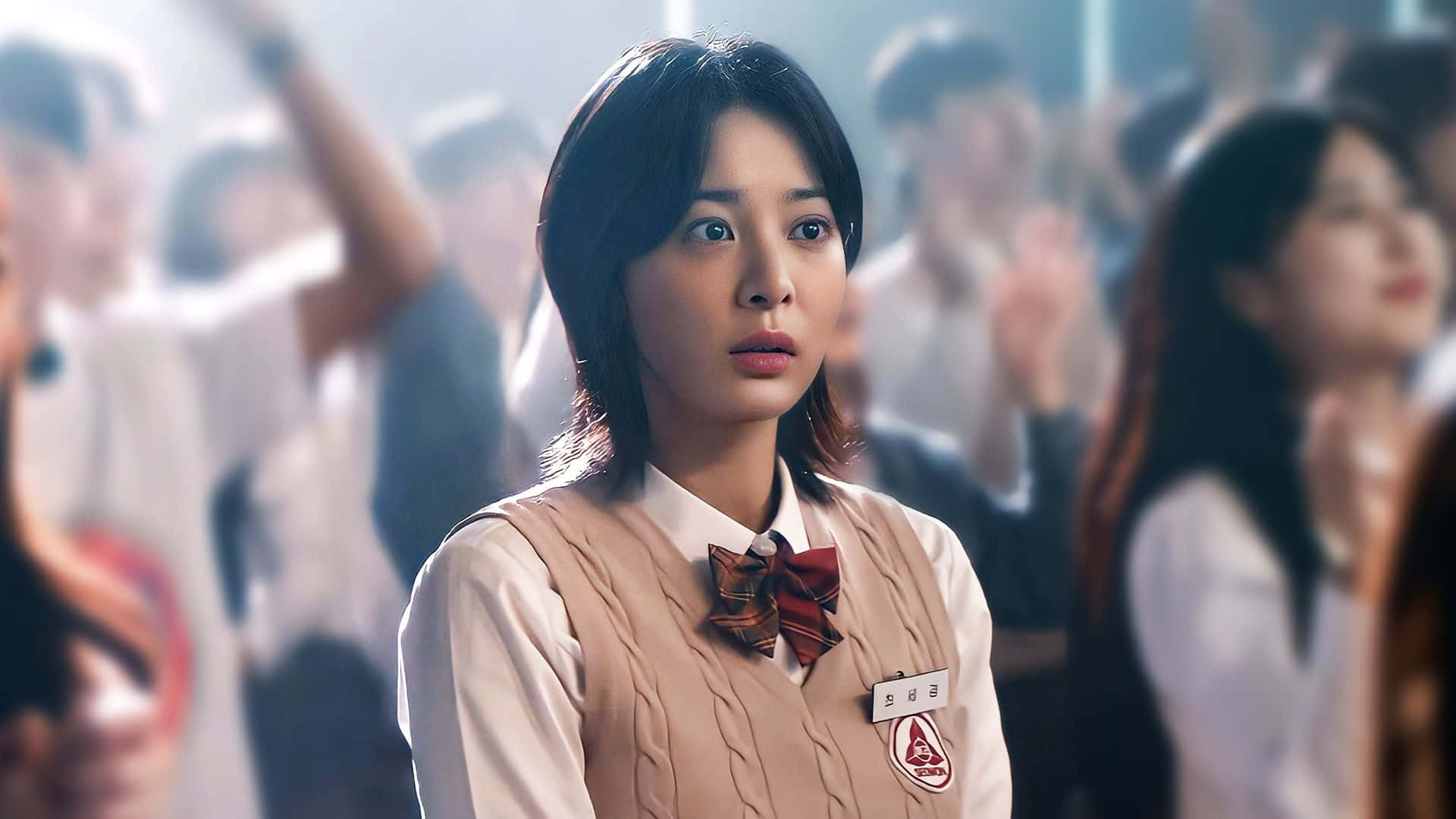  壁紙 — 一名穿著校服的年輕女子睜大眼睛凝視，背景中同學們在歡呼。