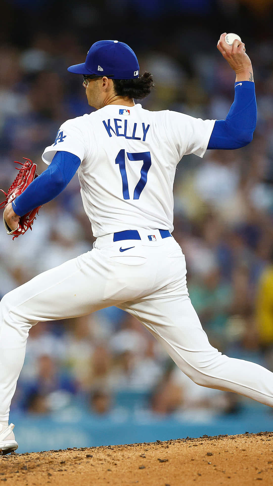  壁紙 — 一名身穿白色和藍色制服、名字為Kelly、號碼17的棒球投手在夜間比賽中準備投球。