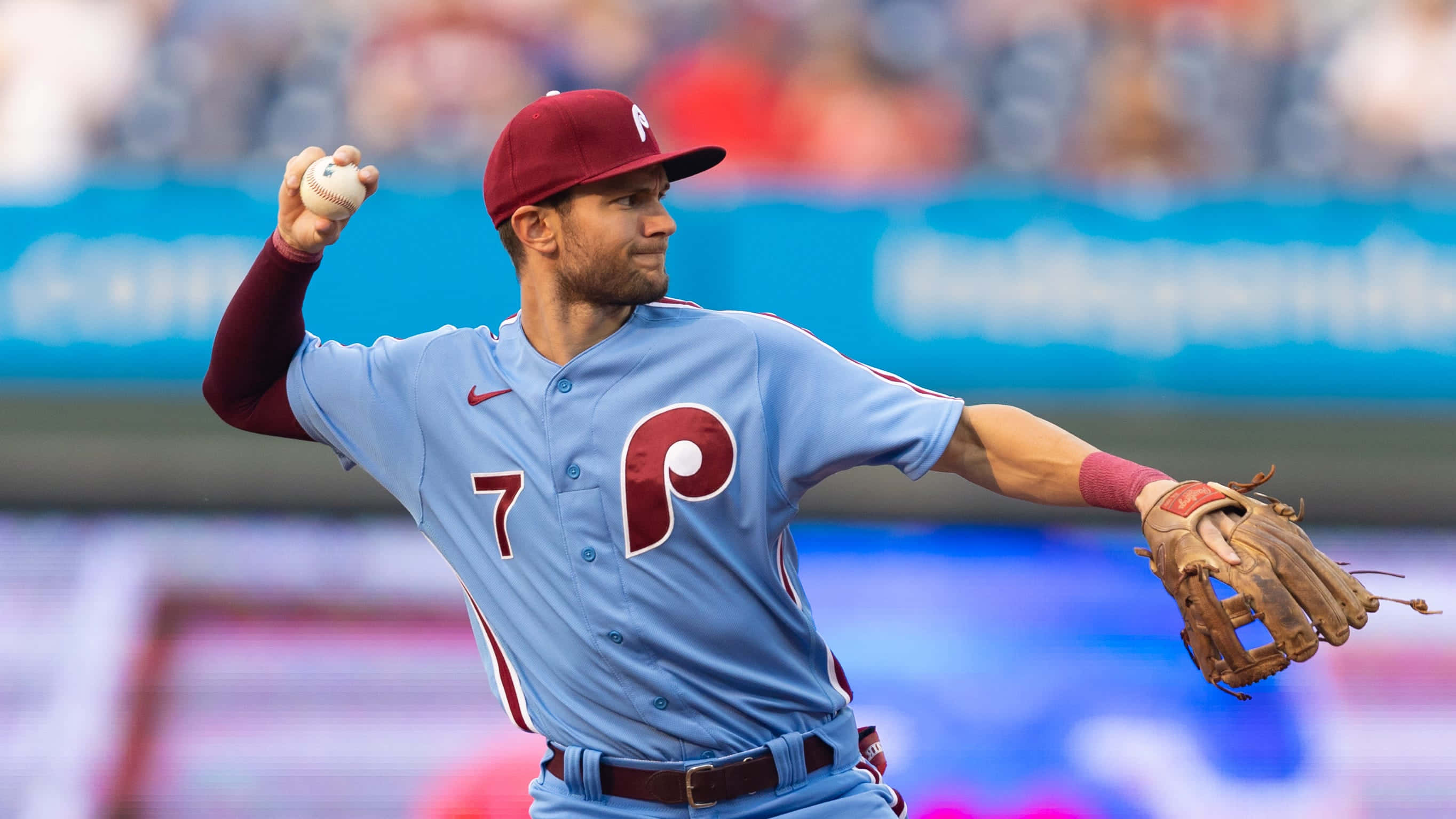 Trea Turner Phillies 桌布 壁紙 — 一名身穿淺藍色和紅色球衣的棒球投手在日間比賽中準備投球。