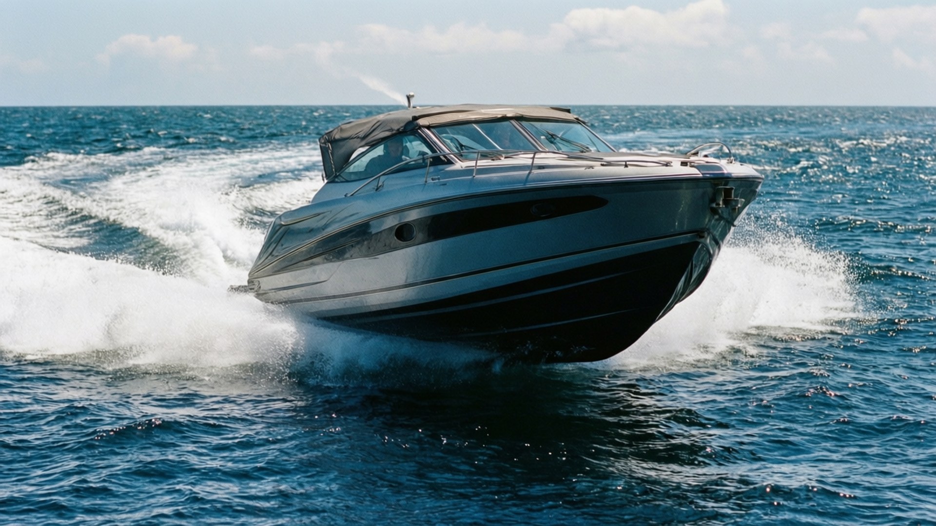 Watercraft 桌布 壁紙 — 一艘流線型快艇在明亮的天空下劃過深藍色的海浪，留下白色的泡沫尾跡。
