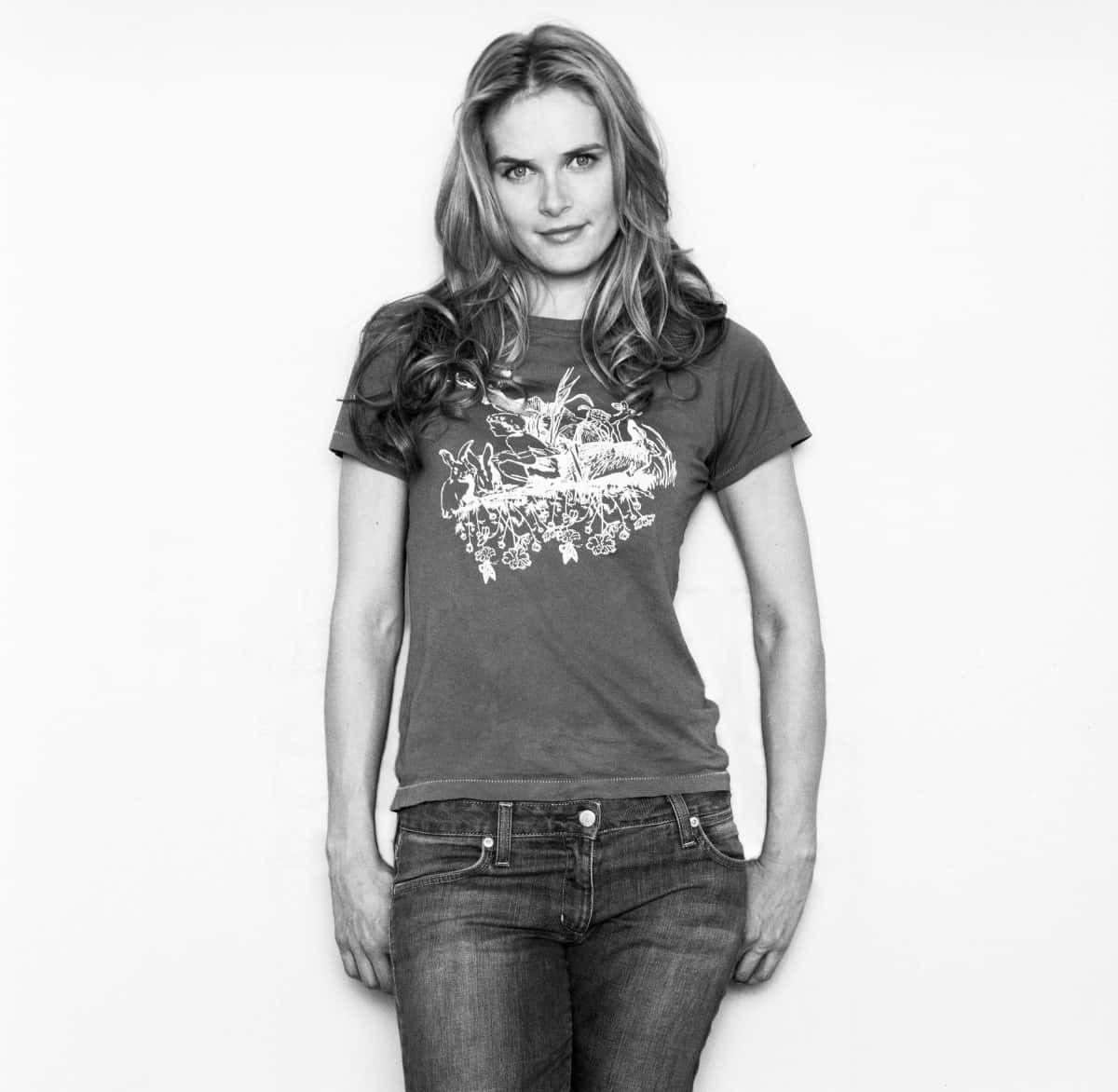 Rachel Blanchard 桌布 壁紙 — 一位穿著圖案T恤和牛仔褲的女性，在純白背景前拍攝的黑白工作室肖像。