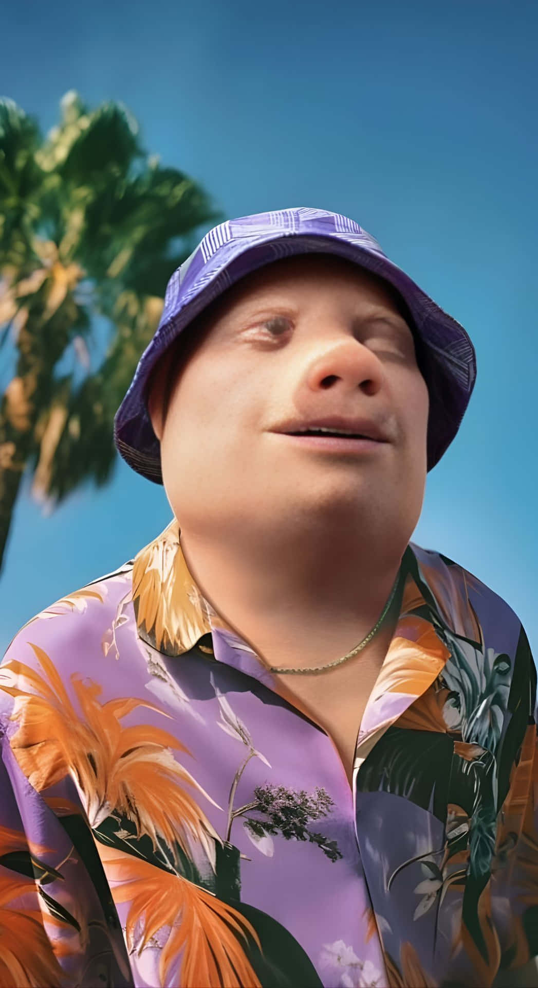  壁紙 — 一位戴著紫色漁夫帽和花卉襯衫的開朗男子在藍天白雲和棕櫚樹下微笑。