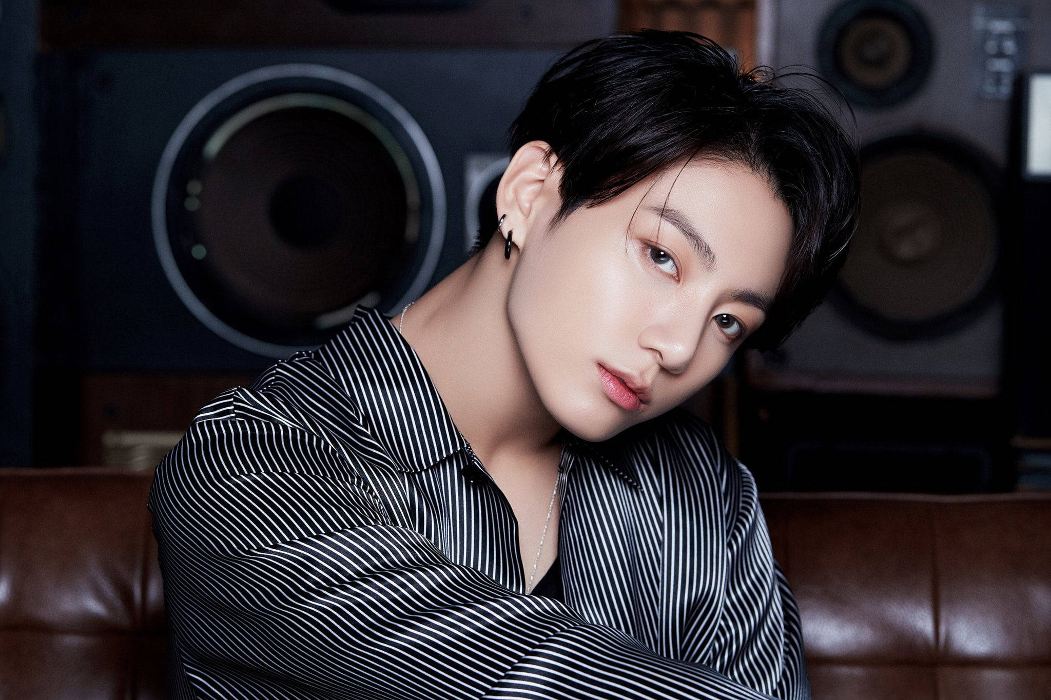 Jungkook身穿絲質襯衫BTS《Life Goes On》 壁紙 — 一位黑髮、身穿黑白條紋襯衫的年輕男子，在大型復古揚聲器的背景下自信地擺姿勢。