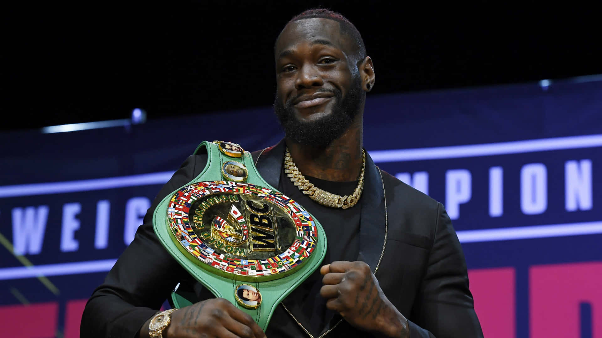  壁紙 — 一位勝利的拳擊手在明亮的場館燈光下自豪地展示他的綠色WBC冠軍腰帶。