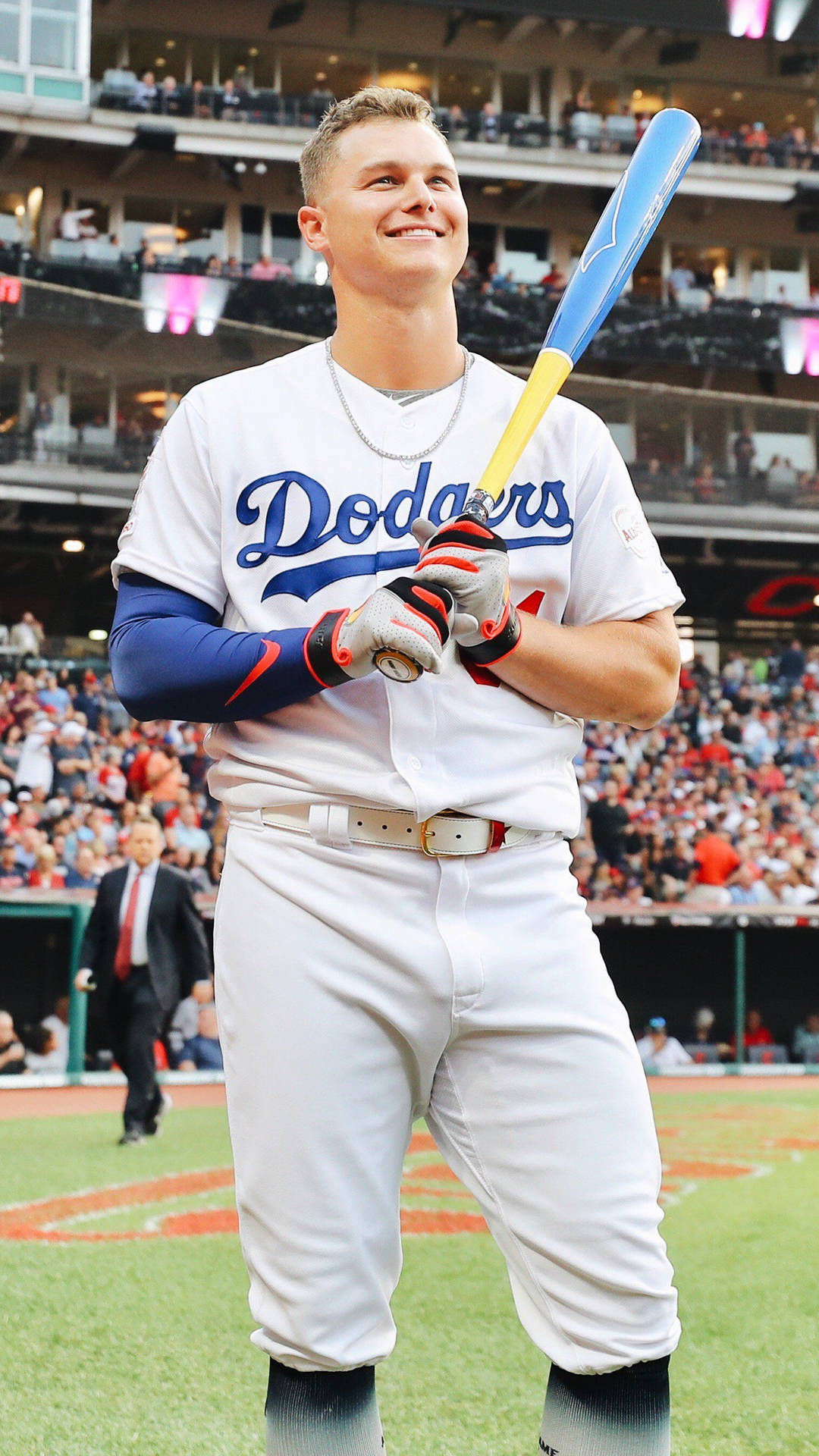 身穿道奇隊制服的棒球運動員在球場上握著球棒，背景有觀眾。